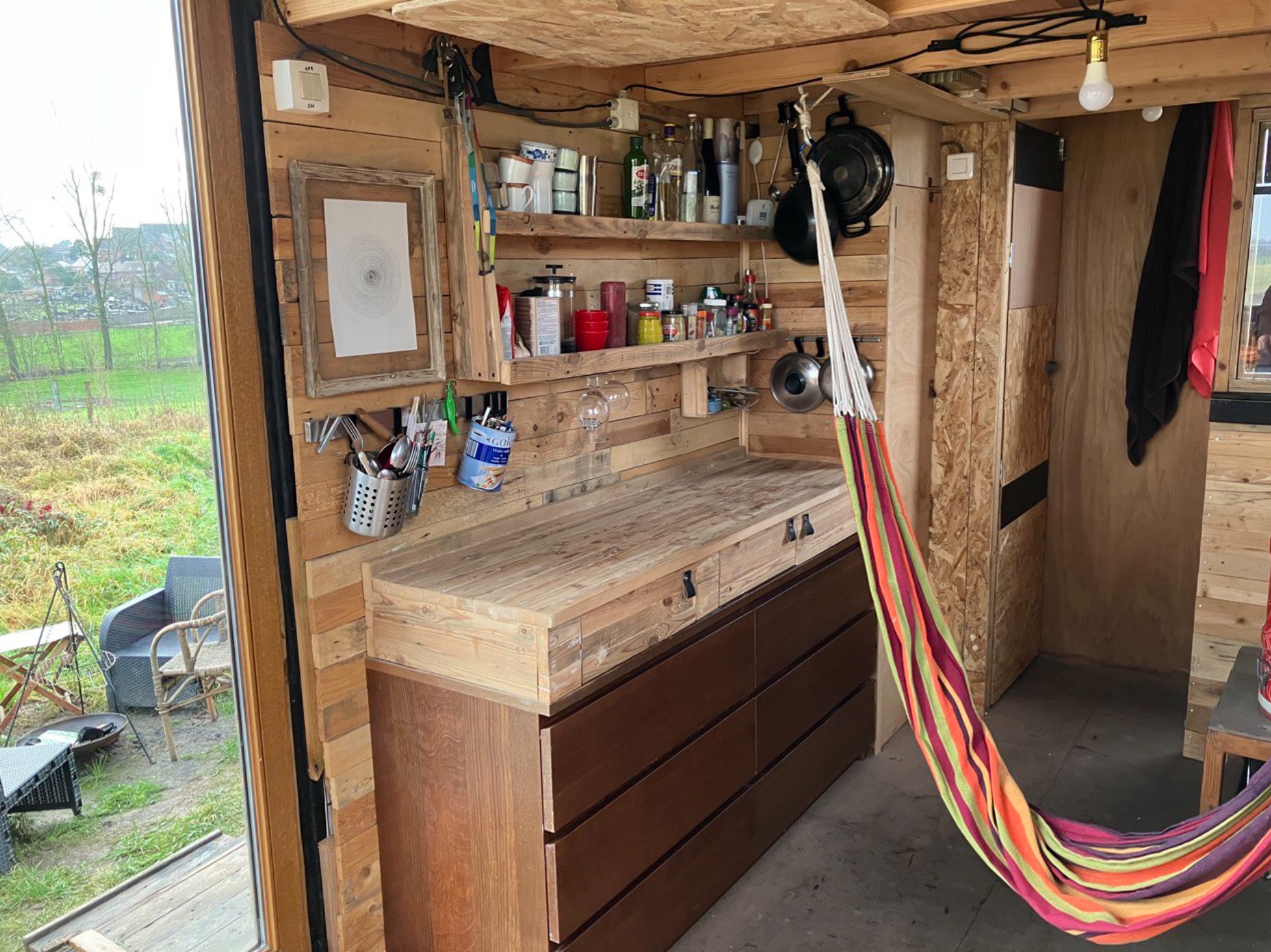 Intérieur aménagé de la tiny house, rangements et cuisine en bois