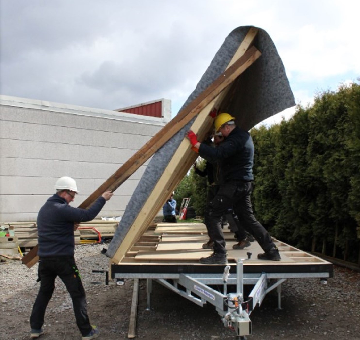 Deux personnes lèvent un mur de la tiny house lors de l’assemblage