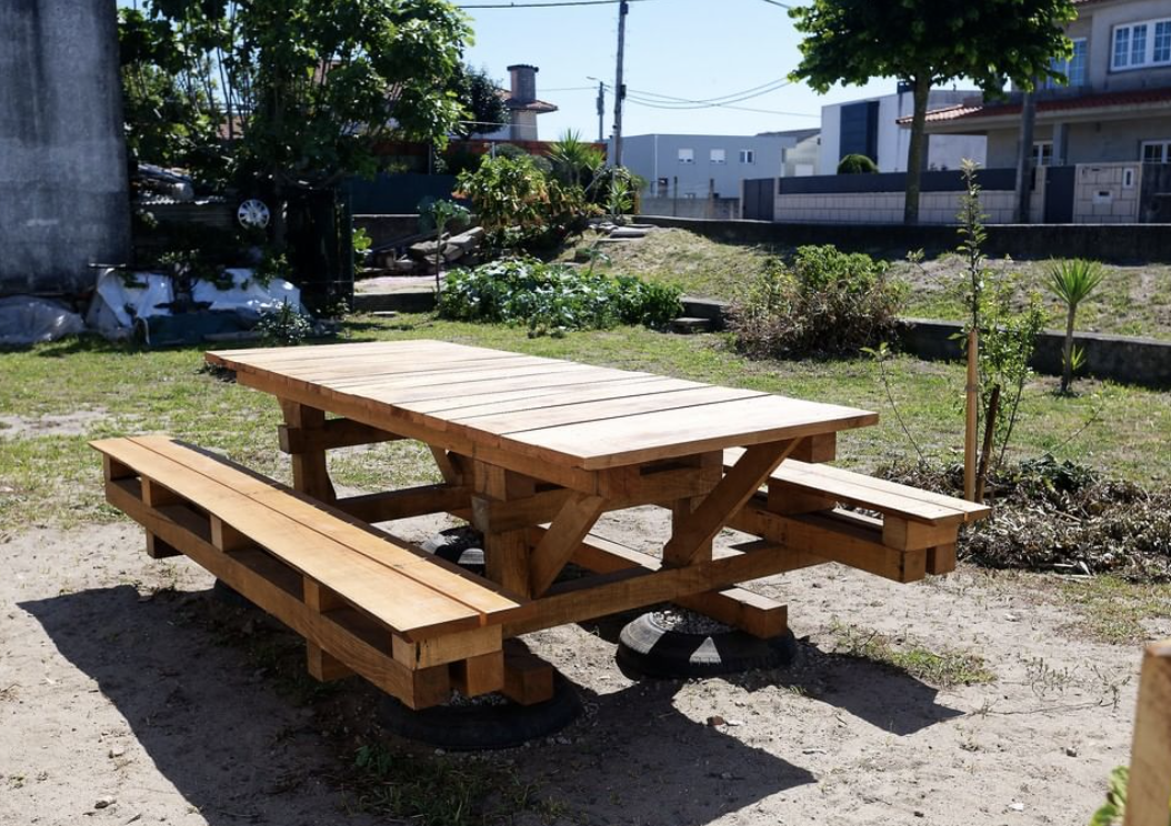 Grande table-banc en bois posée sur l'herbe