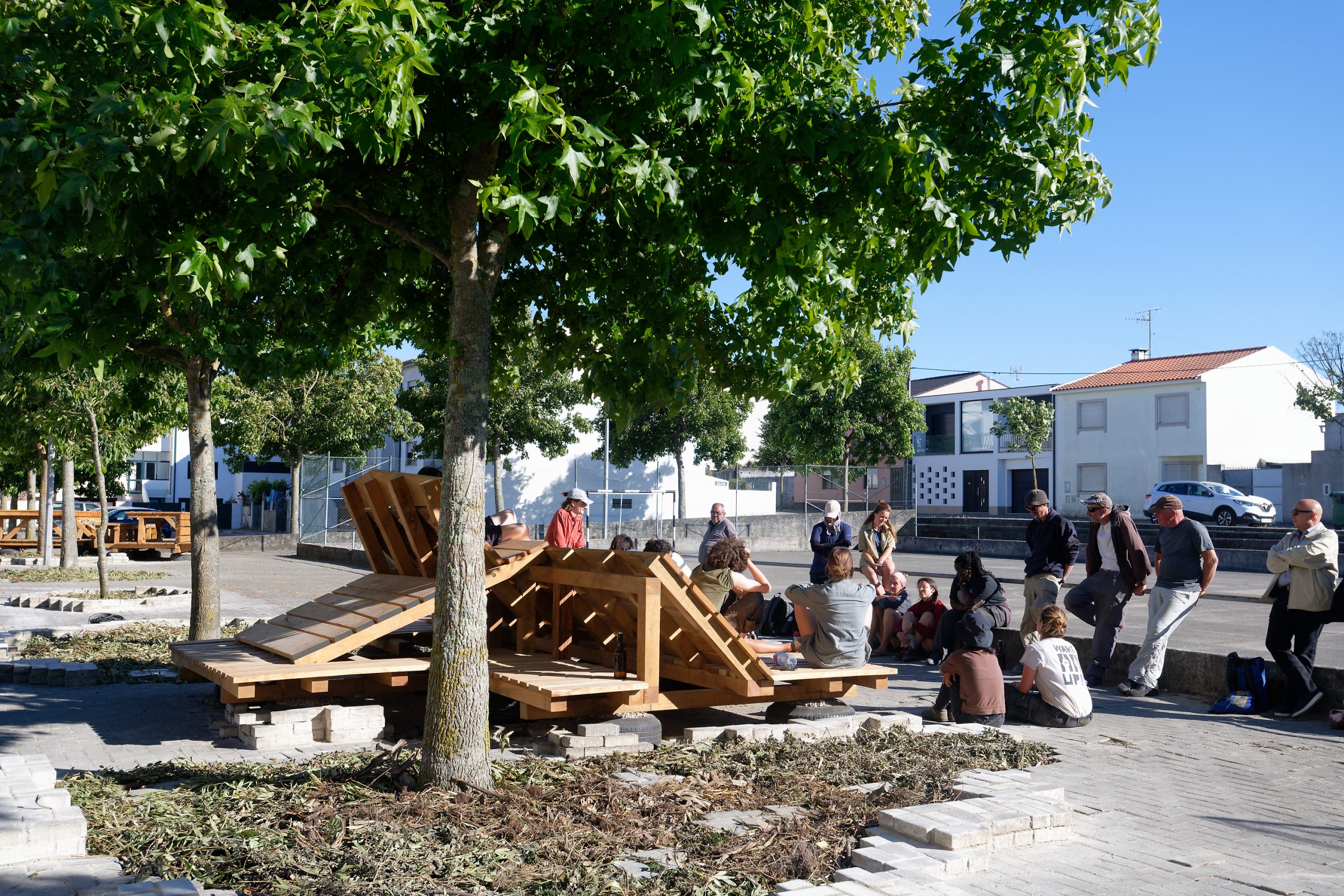 Groupe rassemblé autour des structures bois sous les arbres