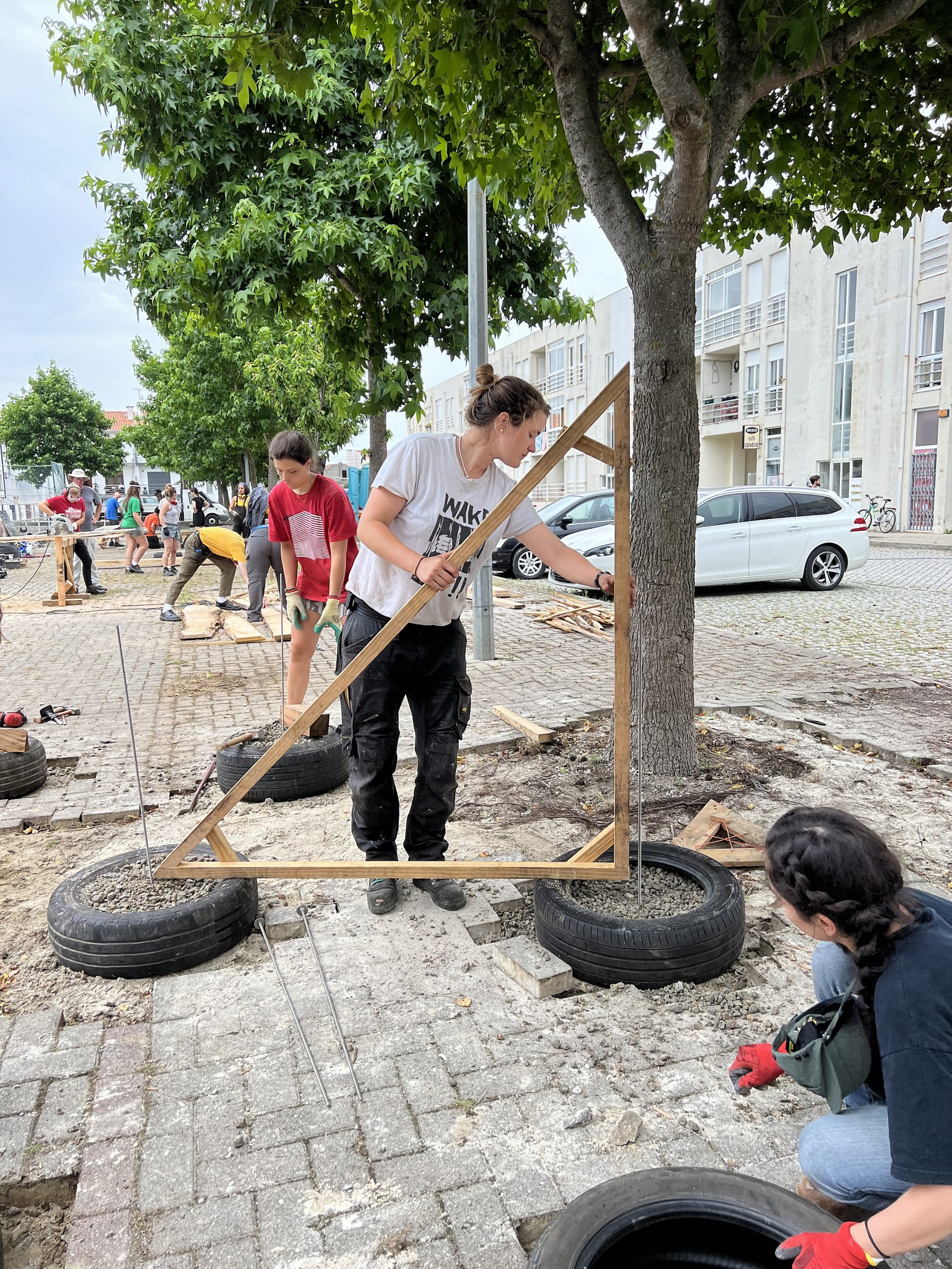 Participants déplaçant des pneus sur la rue pavée