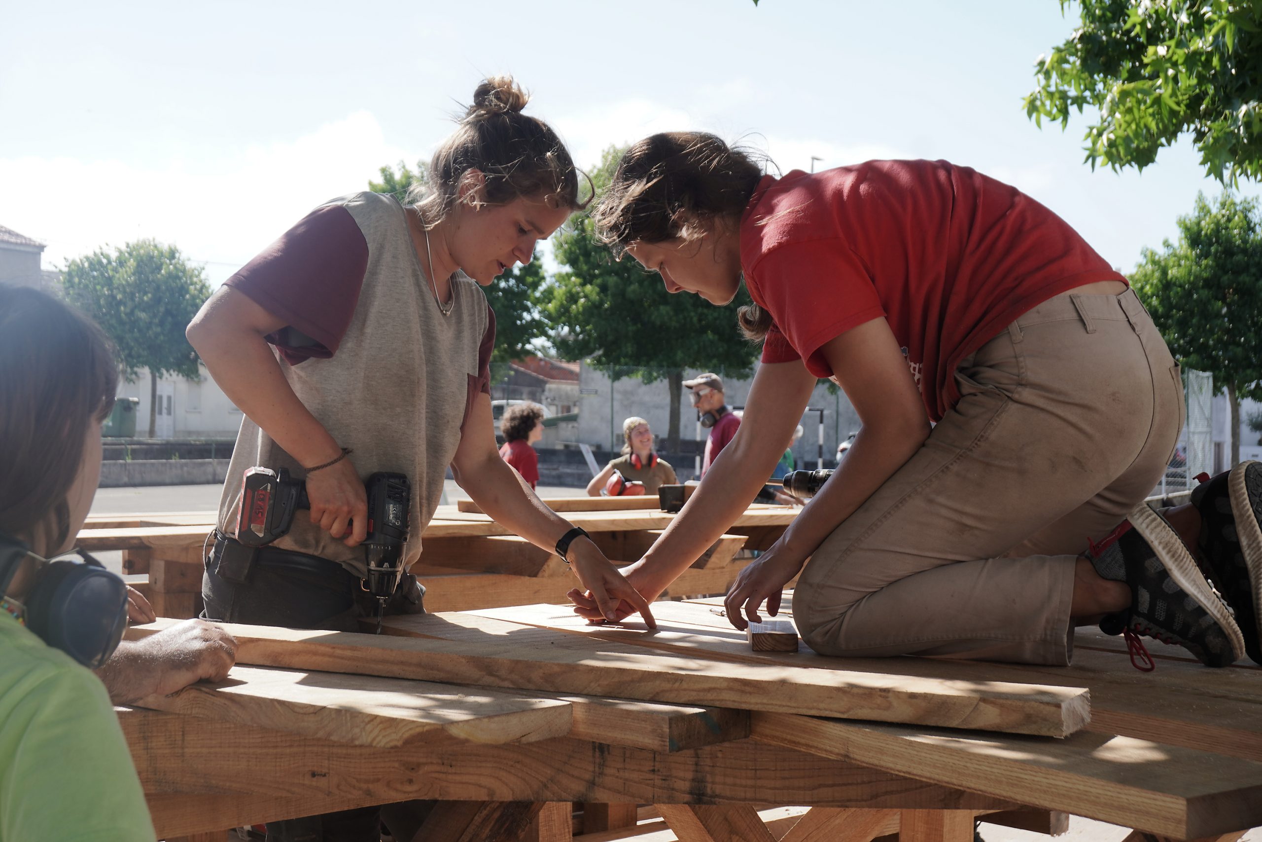 Deux participantes vissent un plateau à genoux