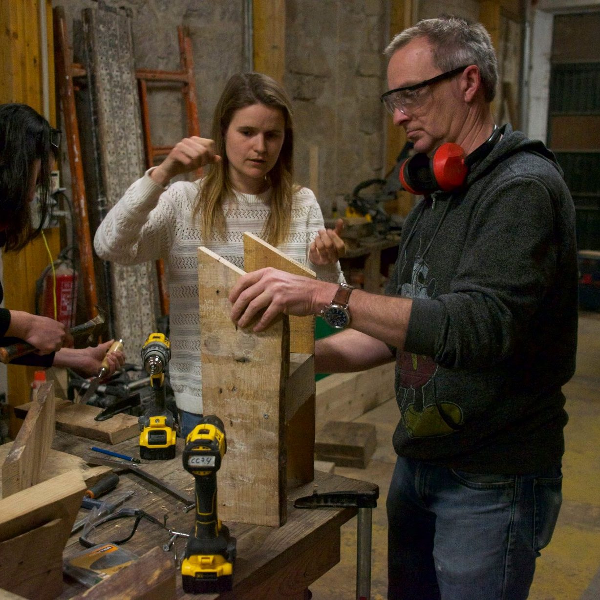 Un formateur montre un assemblage bois à une participante