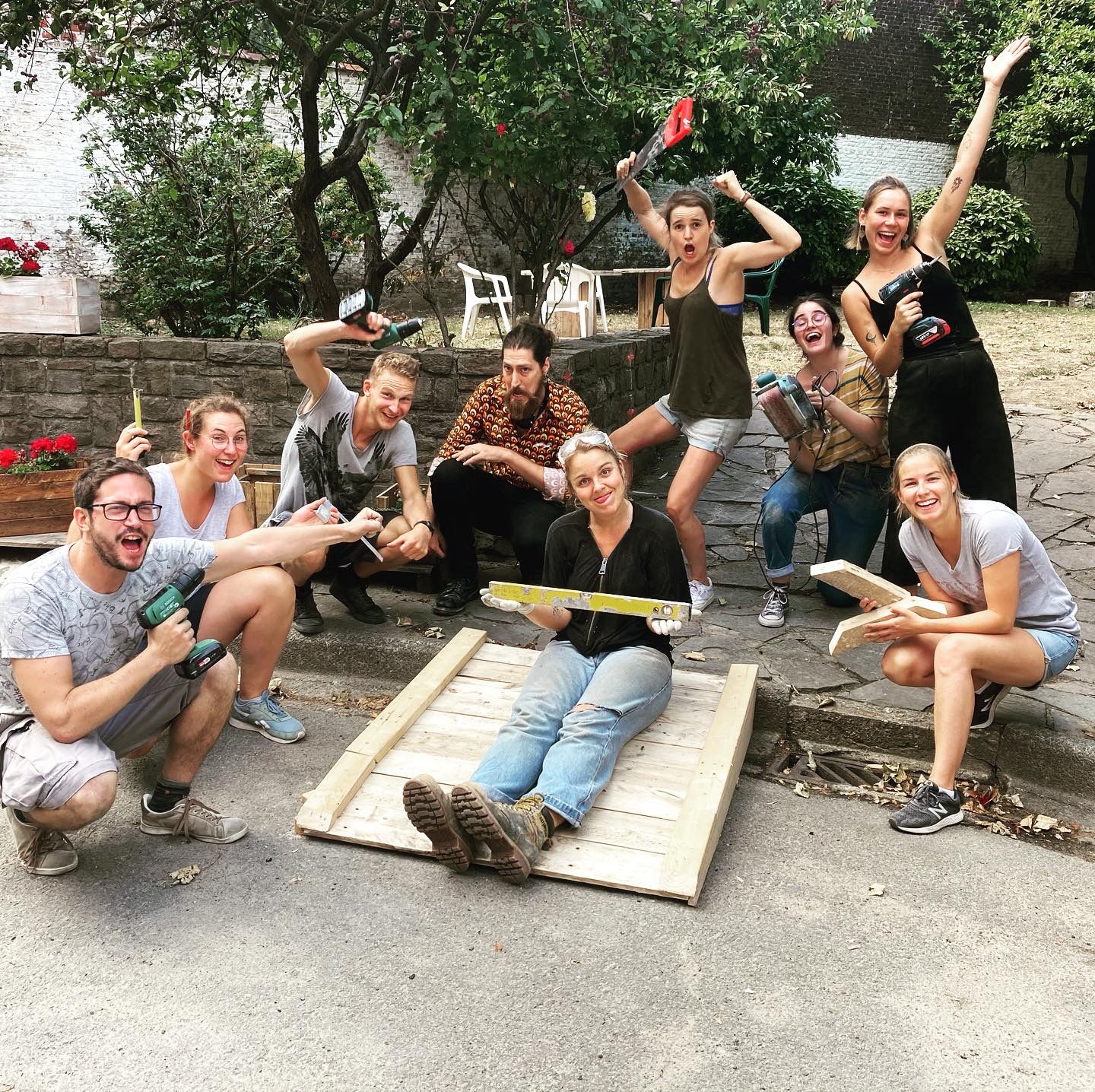 Photo de groupe joyeuse autour d'une planche dans la cour
