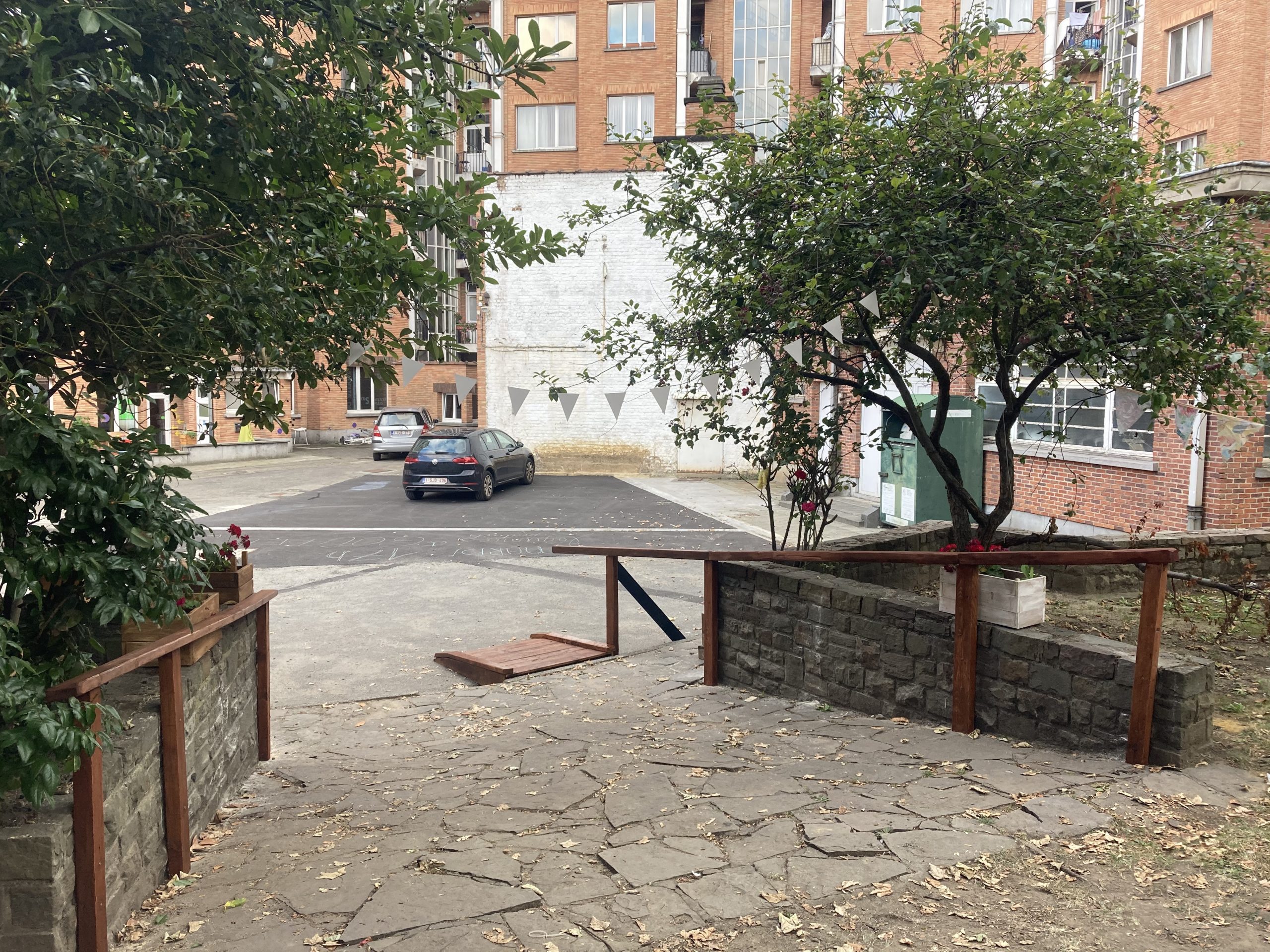 La cour aménagée de bacs et de mobilier en bois