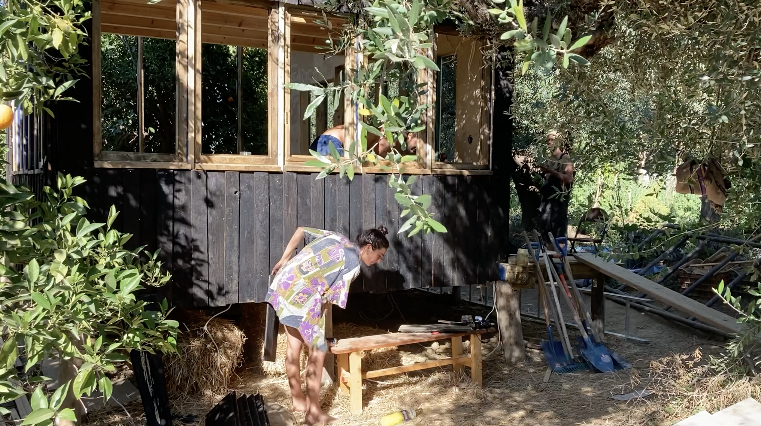 Une participante travaille sous le mini habitat, façade brûlée
