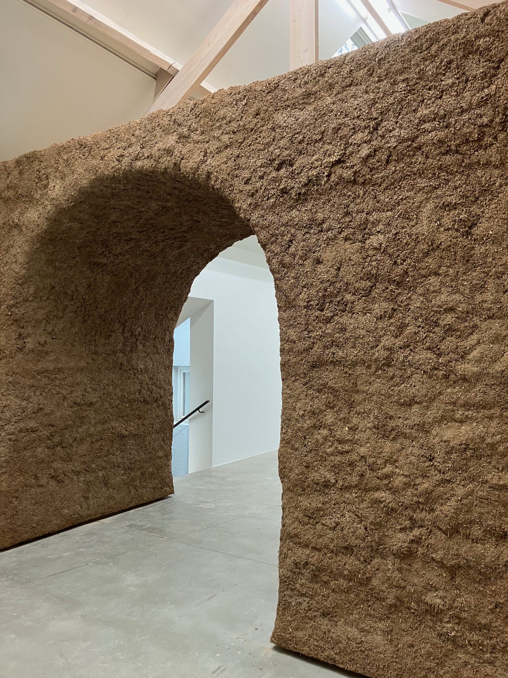 Passage voûté du portique en chaux-chanvre ouvrant sur la galerie