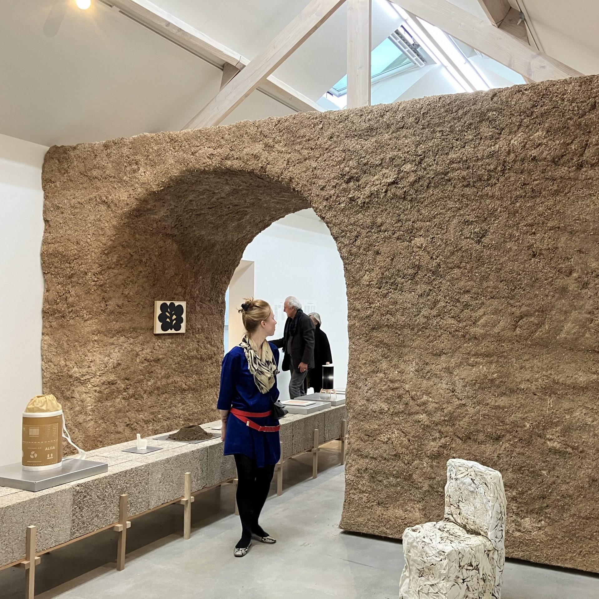 Une visiteuse observe le portique en chaux-chanvre dans l'exposition