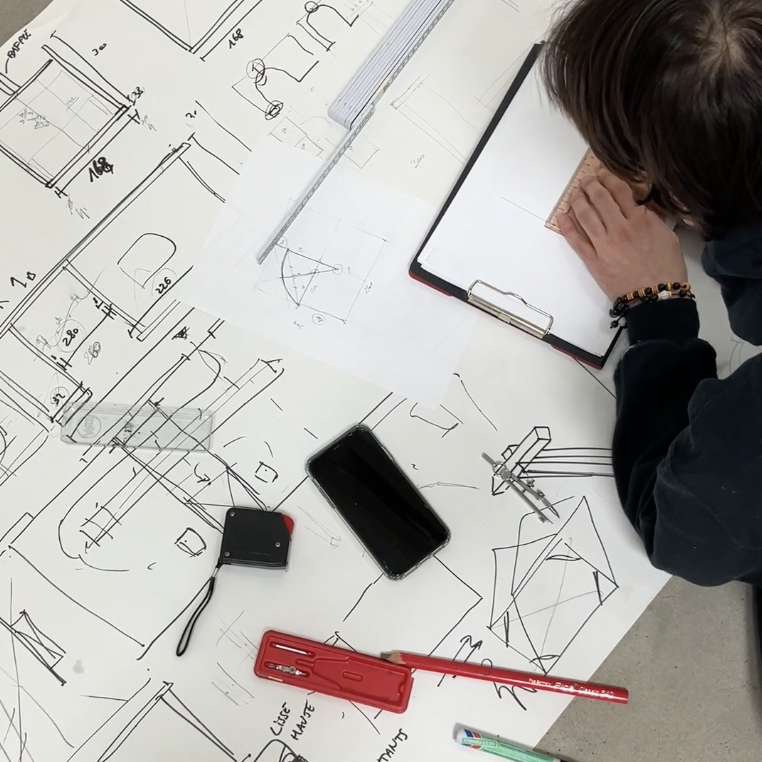 Croquis d'étude du portique étalés sur une table