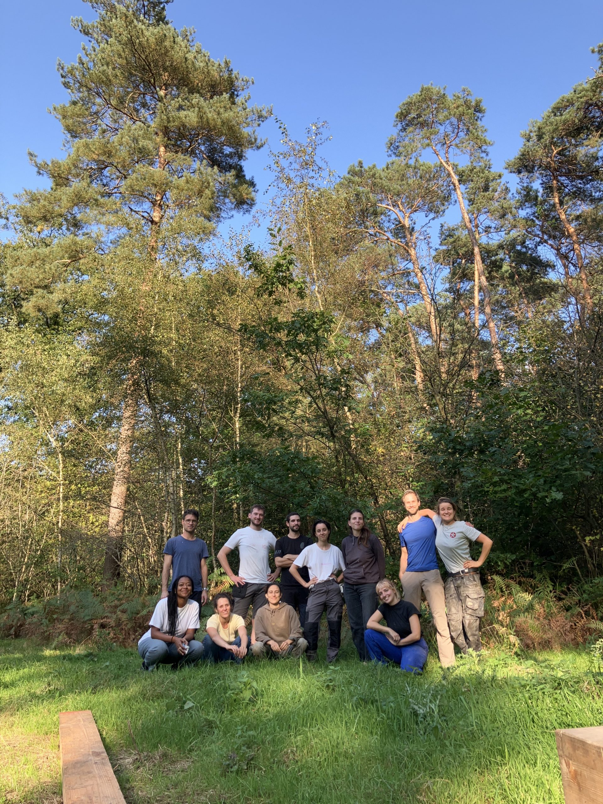 Groupe de participants réuni dans le sous-bois près du chantier