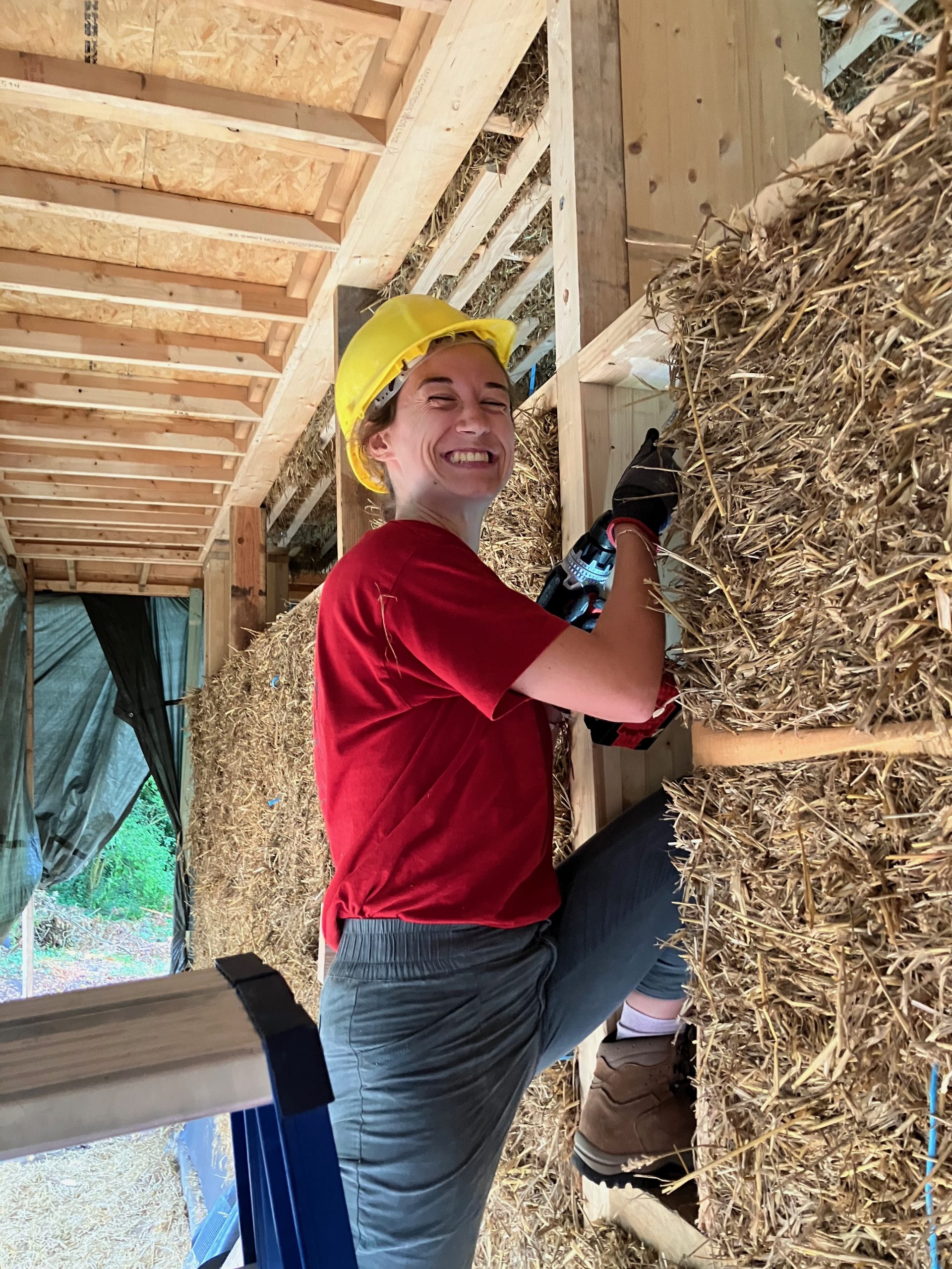 Un participant fixe un ballot de paille au mur à la visseuse