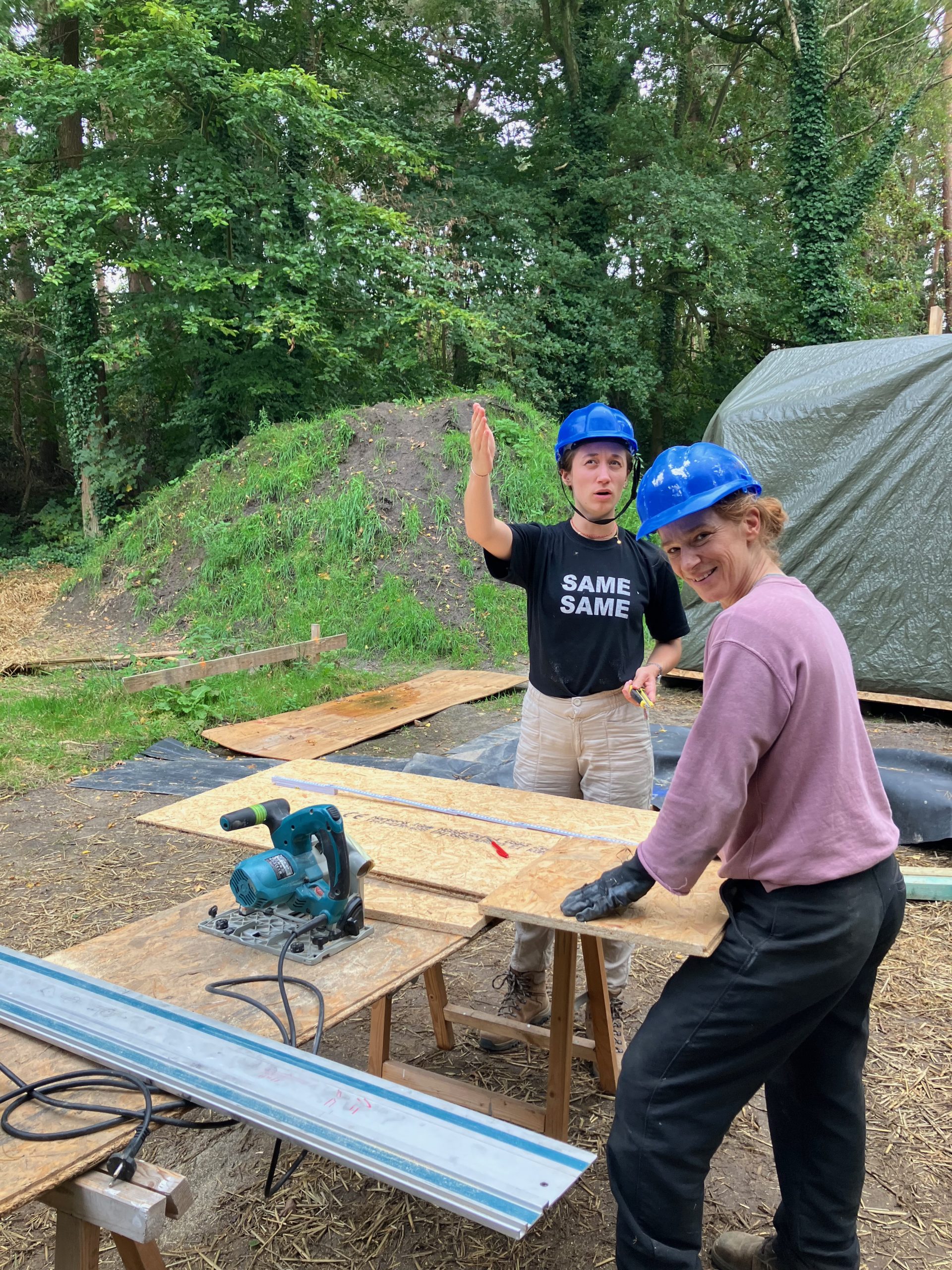 Deux participants découpent des montants bois à la scie