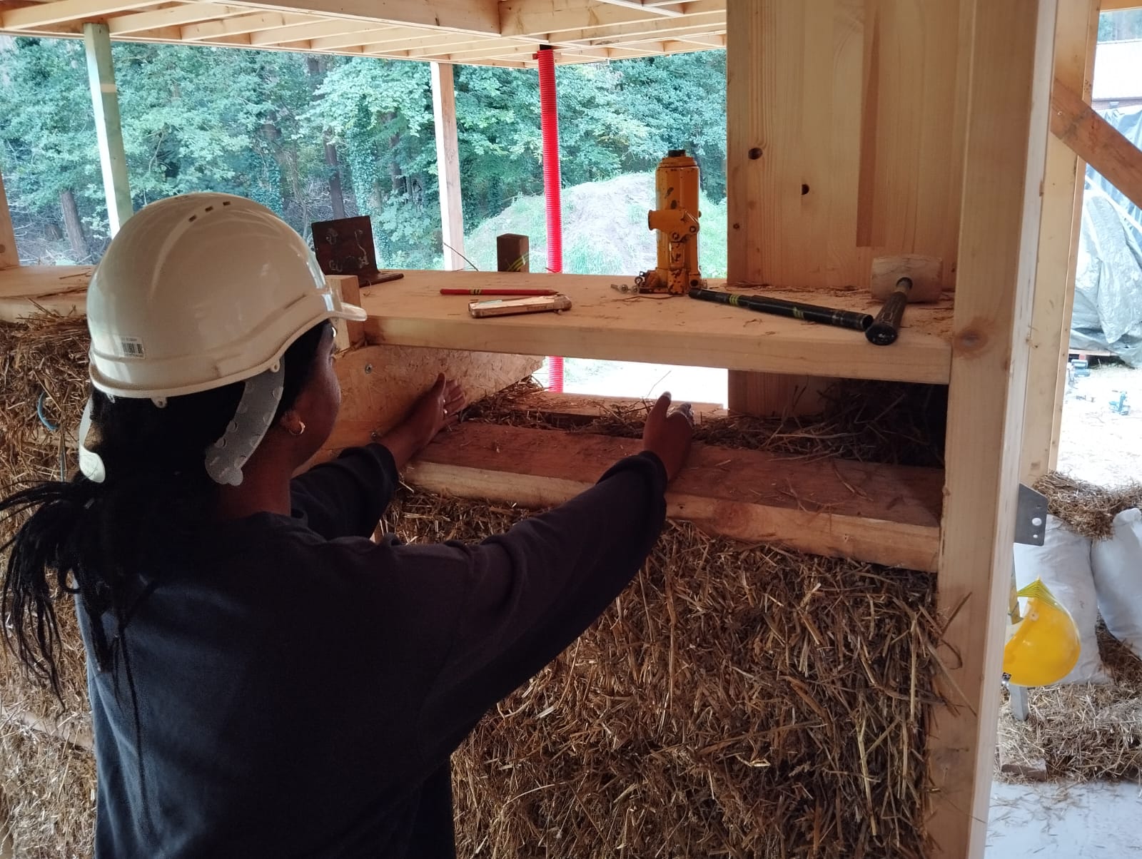 Une participante assemble une structure bois remplie de paille