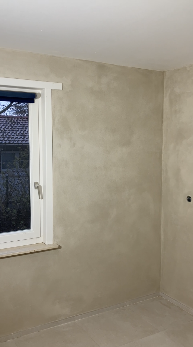 Mur intérieur fini à la chaux autour d'une fenêtre, teinte sable clair