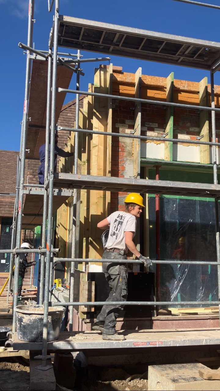 Un participant travaille sur l'échafaudage devant la façade en chantier