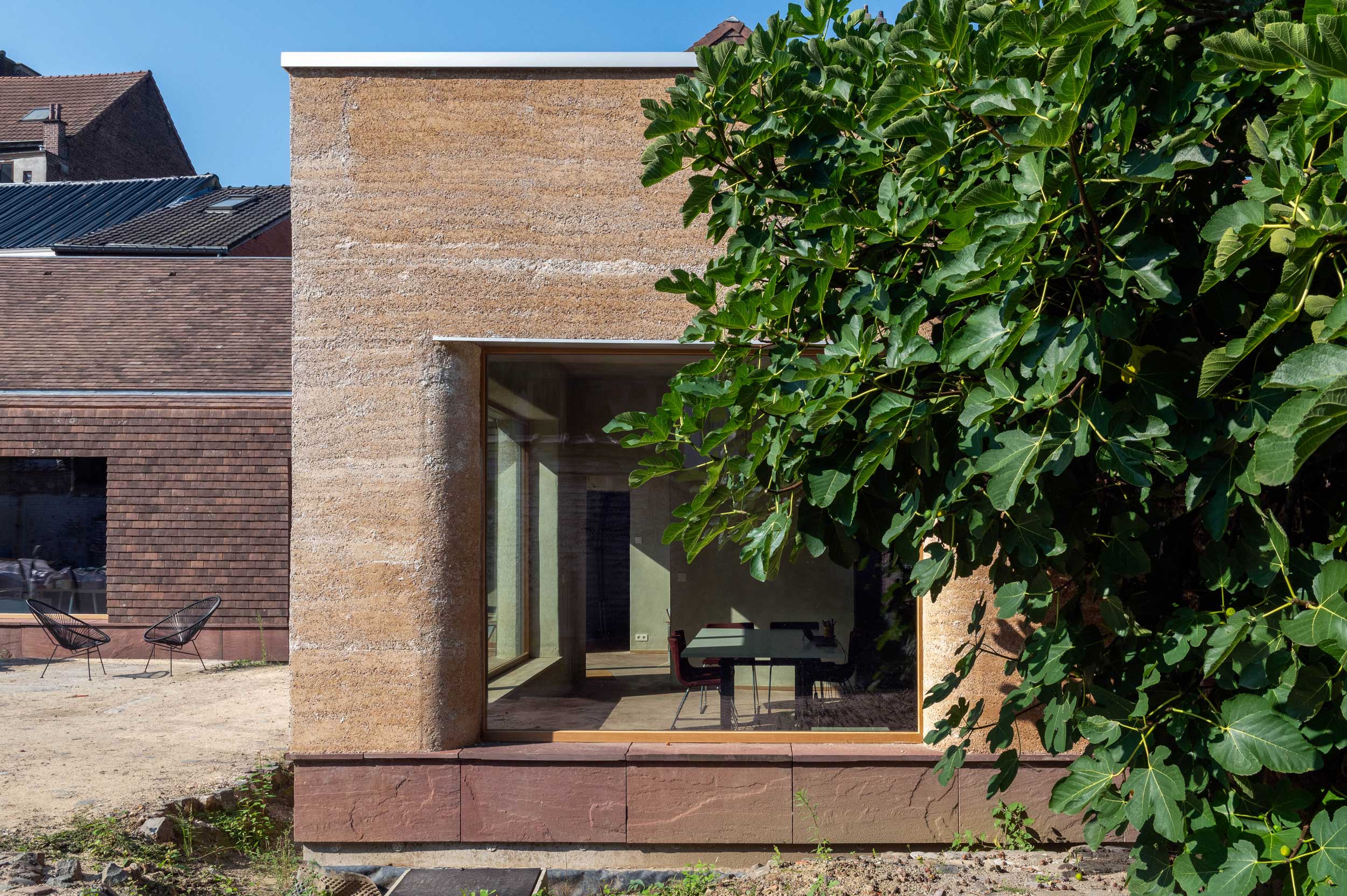 Façade terminée vue depuis le jardin, végétation au premier plan
