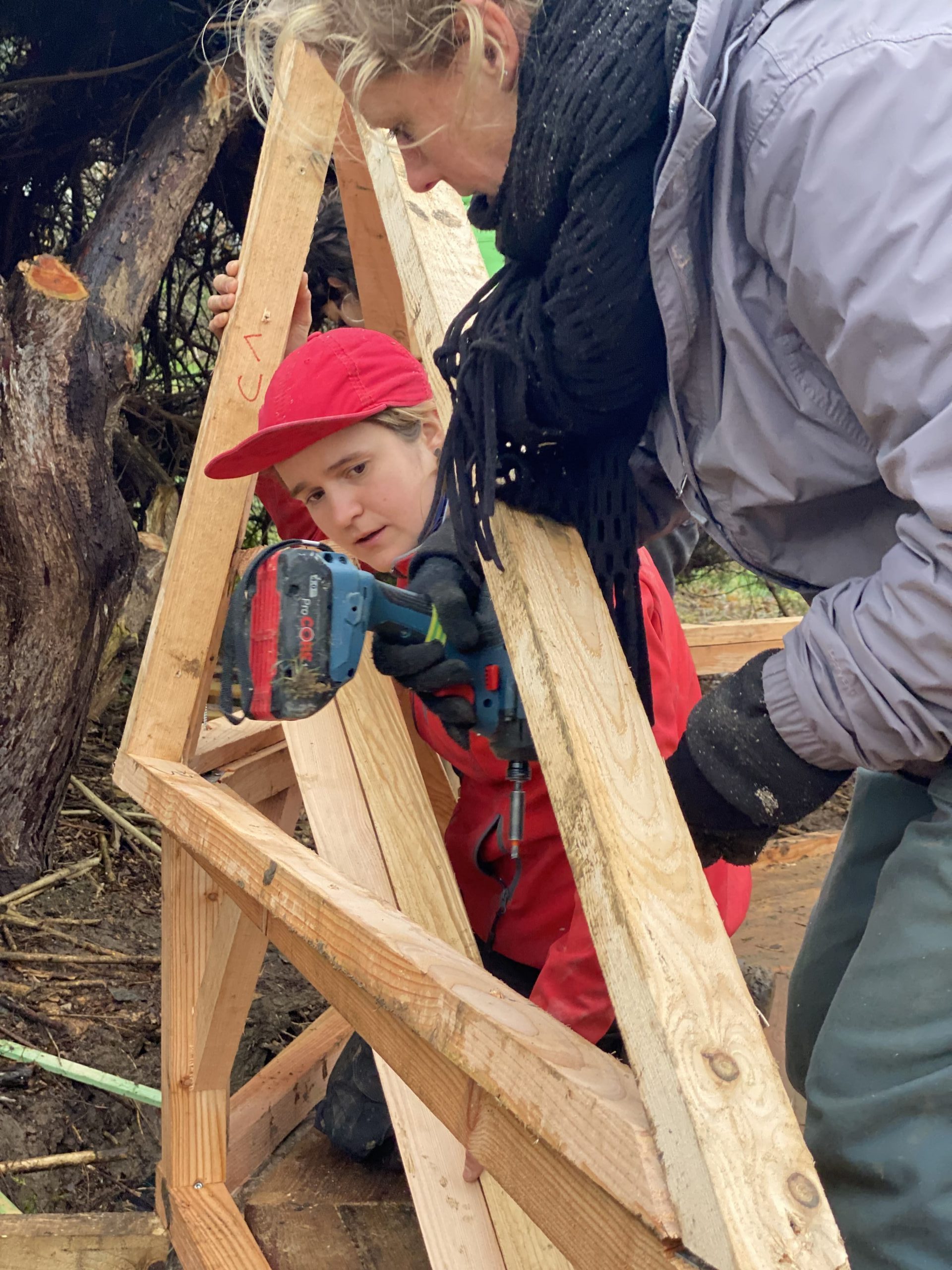Un enfant casqué aide à porter une membrure du dôme