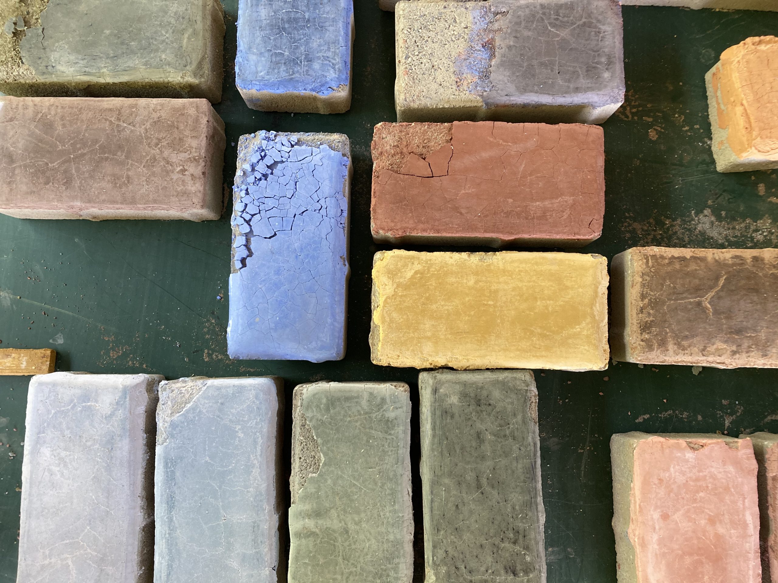Détail de galets colorés incrustés dans un mur au tadelakt vert