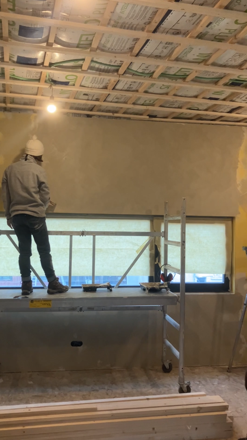 Un participant travaille en hauteur près d'une baie, plafond en bois