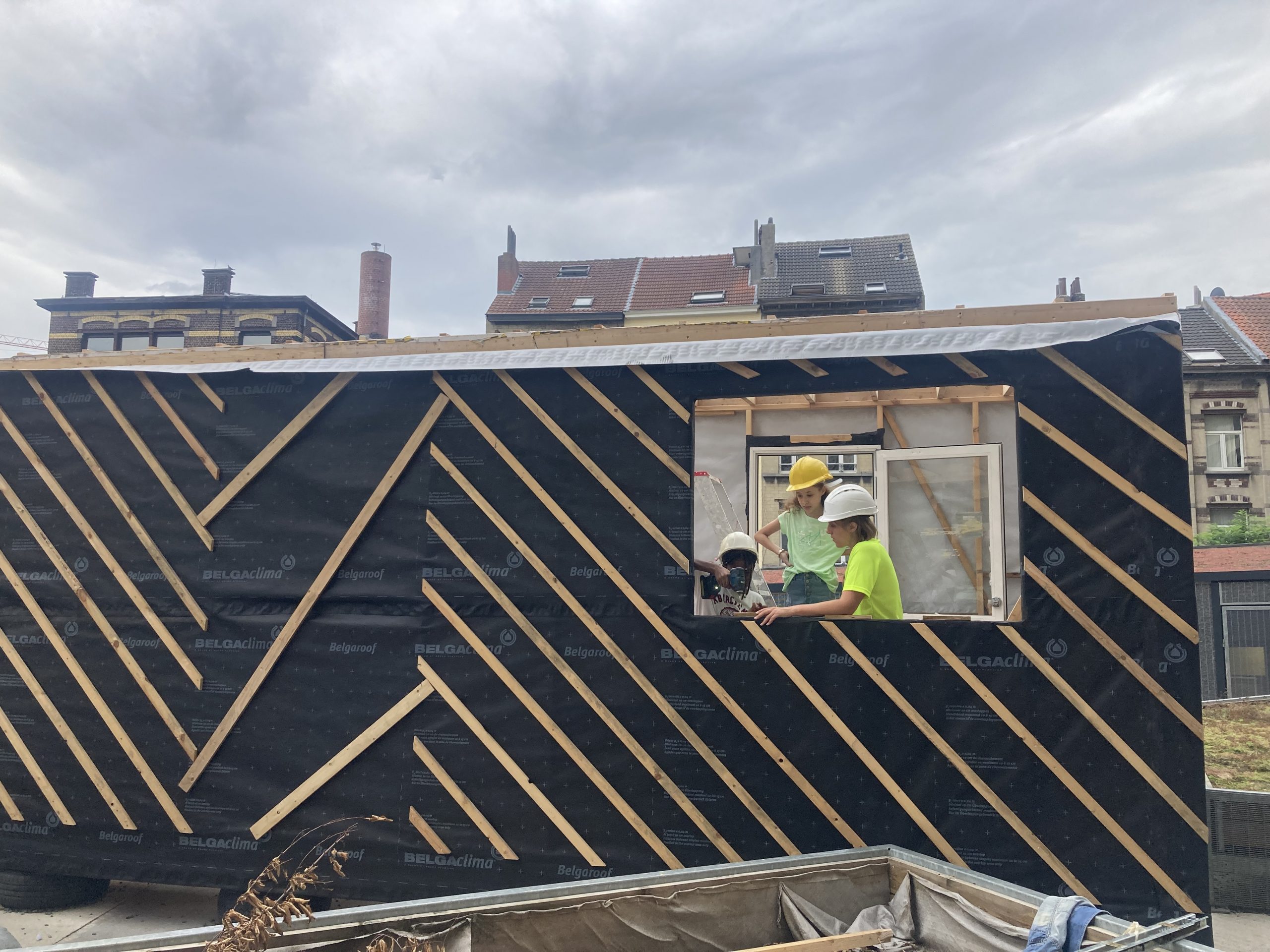 Toiture en losanges de bois du pavillon, participants au travail près d'une fenêtre