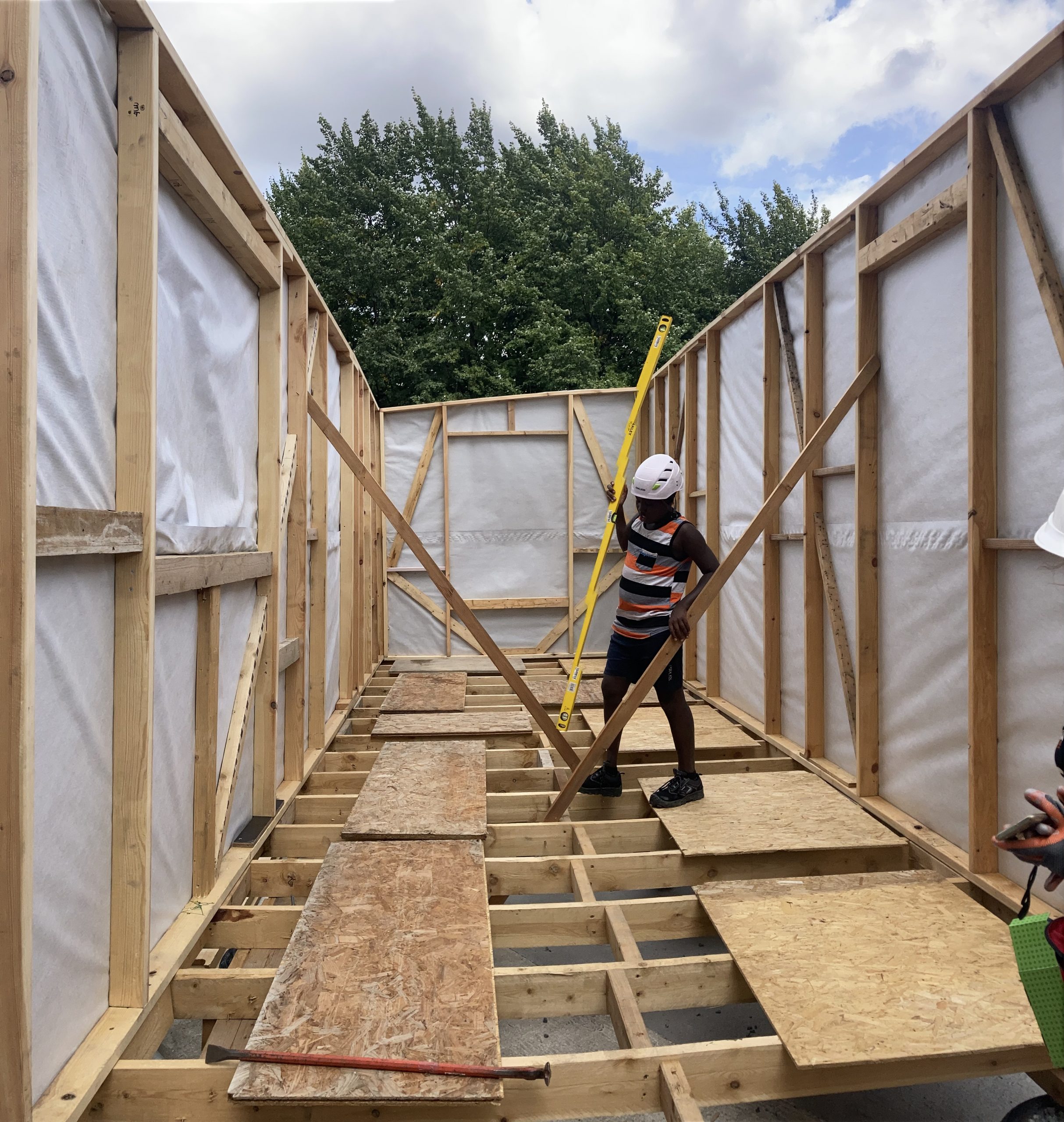 Ossature bois du pavillon bâchée, un participant sur le plancher central