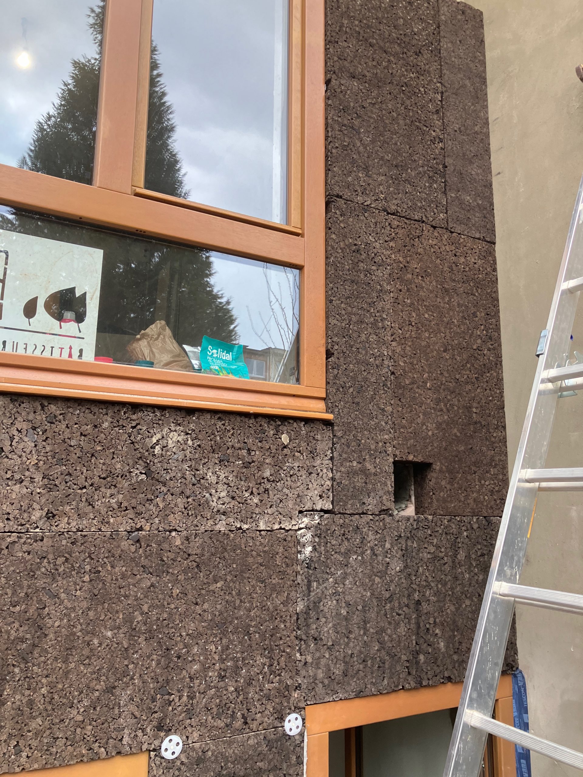 Façade isolée en liège, fenêtres posées à fleur de l'isolant