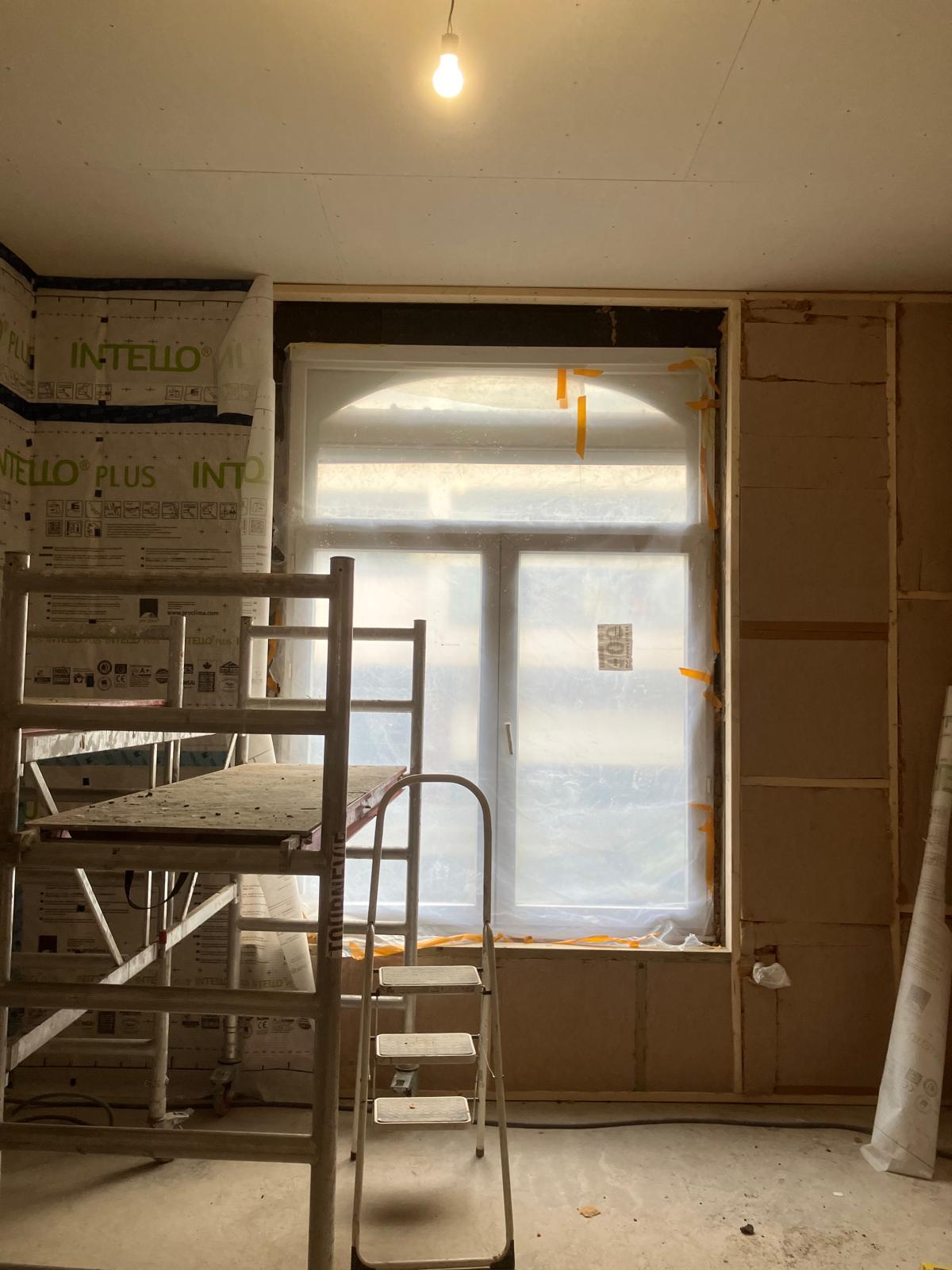 Pièce en rénovation, embrasure de fenêtre et échafaudage roulant
