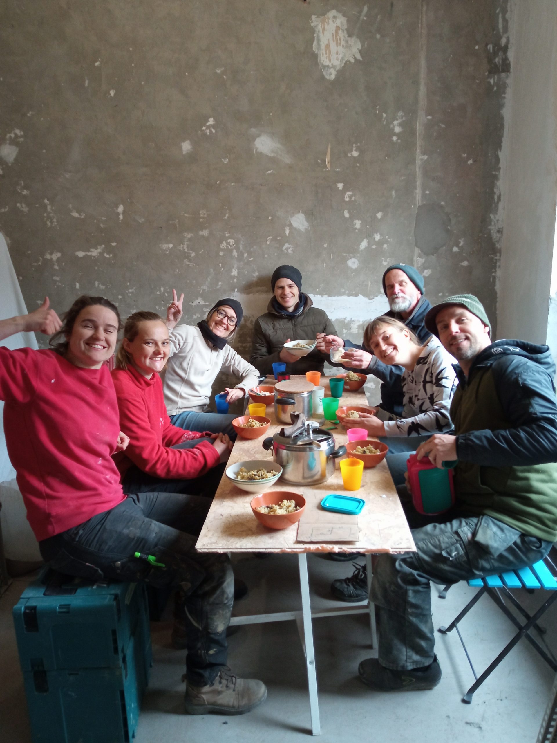 Le groupe partage un repas convivial autour d'une table sur le chantier