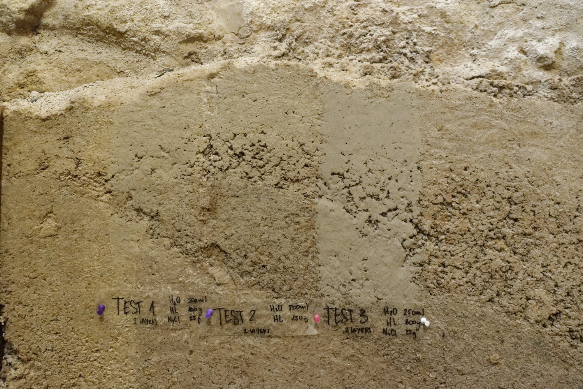 Échantillons d'isolant chaux-carton étiquetés contre un mur