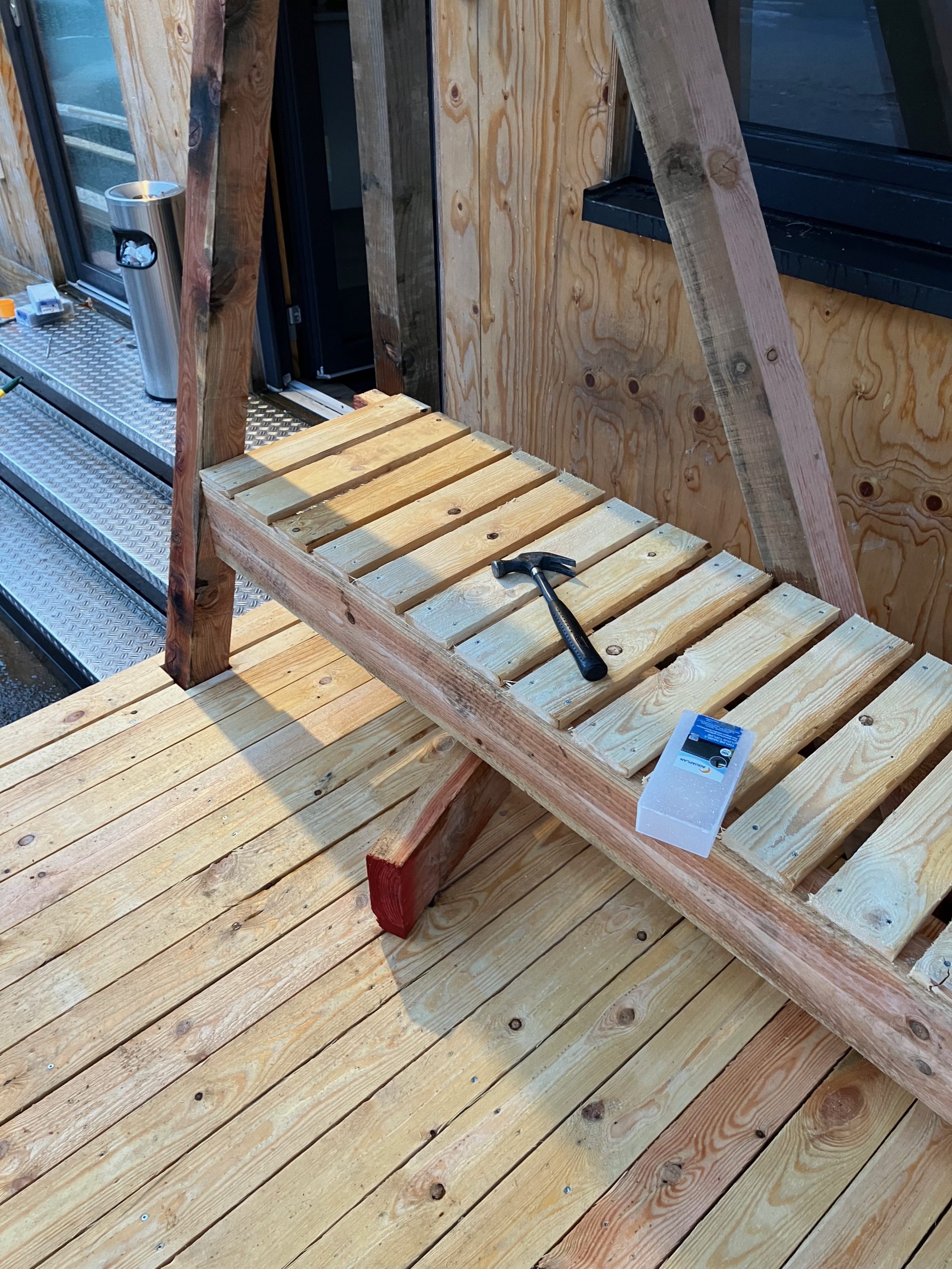 Planches de terrasse en cours de pose sous la charpente
