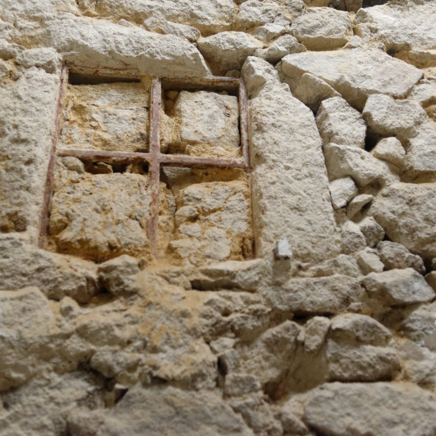 Ancienne fenêtre en bois encastrée dans un mur en granit