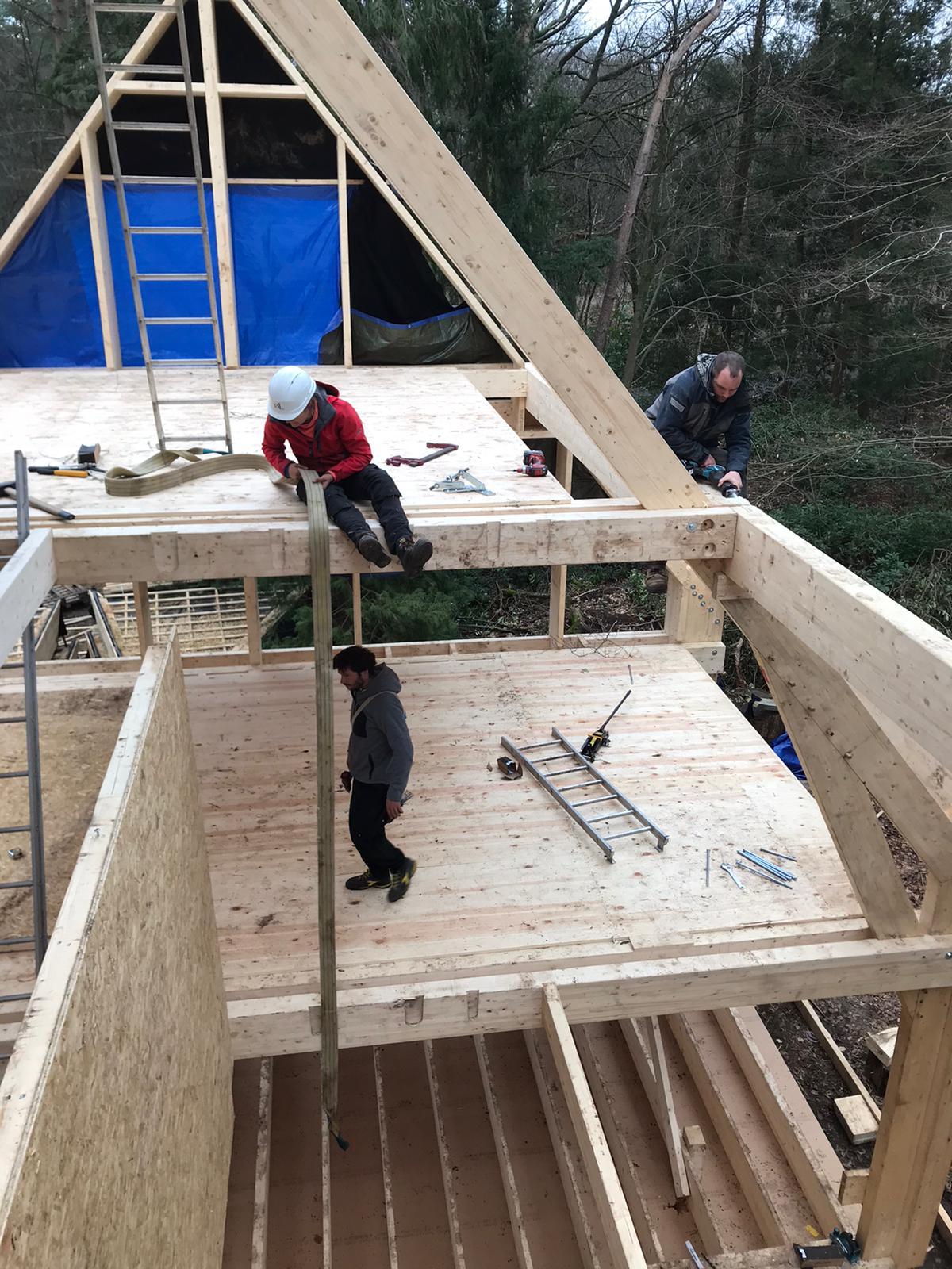 Participants relevant l'ossature de la maison, échelle appuyée