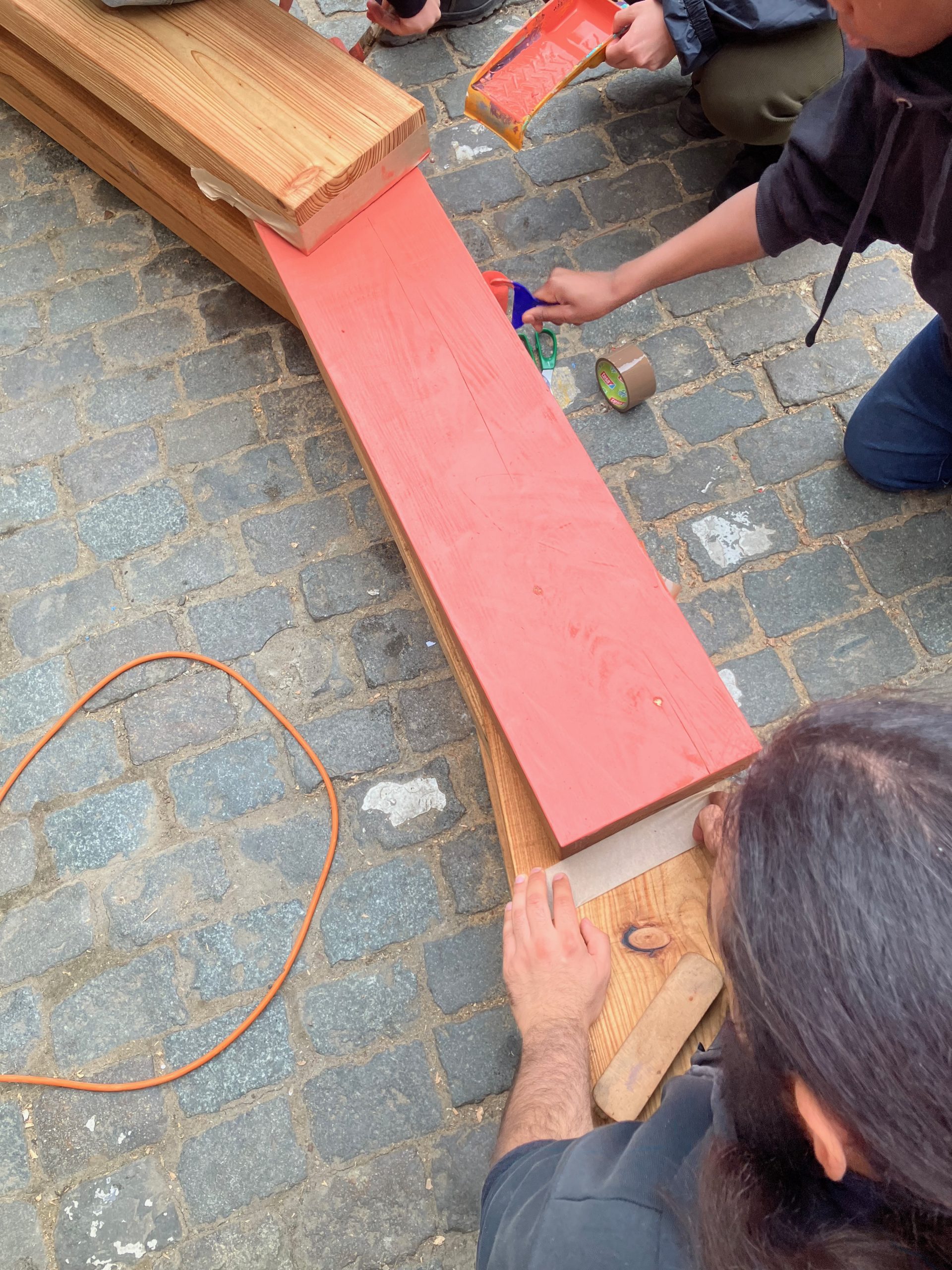 Une participante ponce une assise rouge au sol