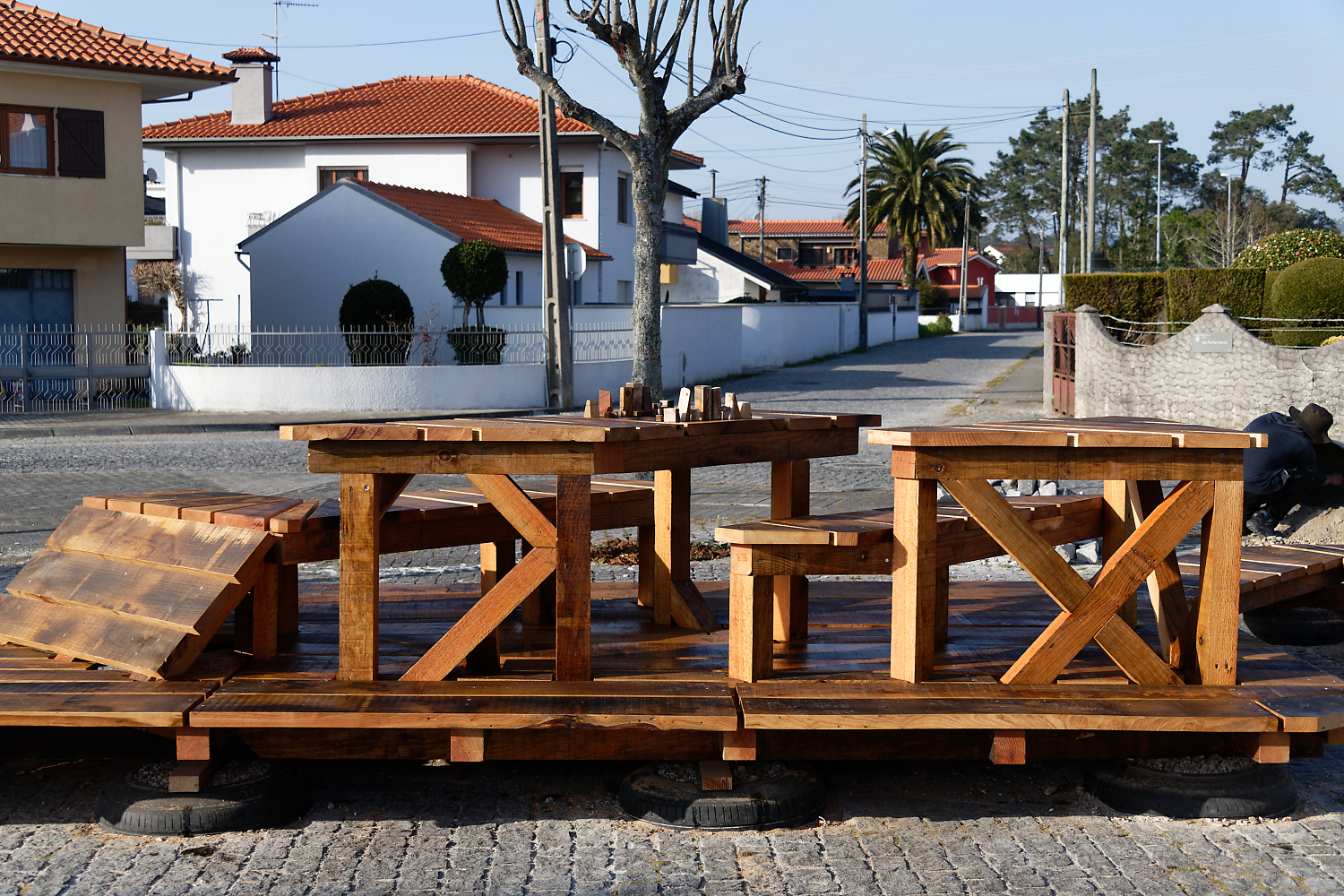Le mobilier urbain en bois installé sur la place, maisons en fond