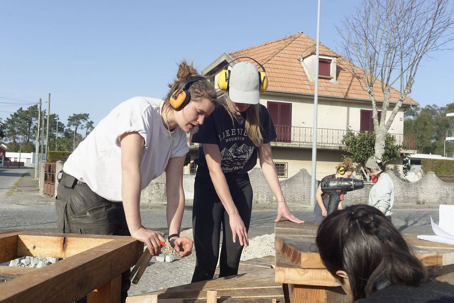 Une participante ponce une pièce de bois en extérieur