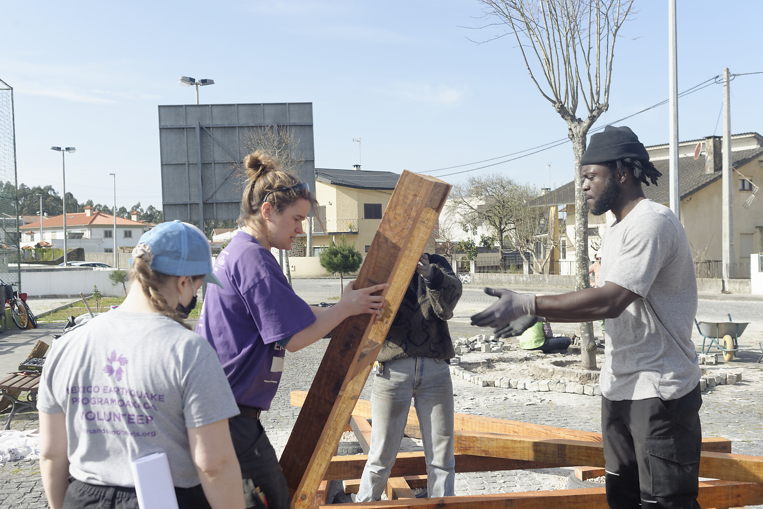 Participants soulevant une planche de bois ensemble