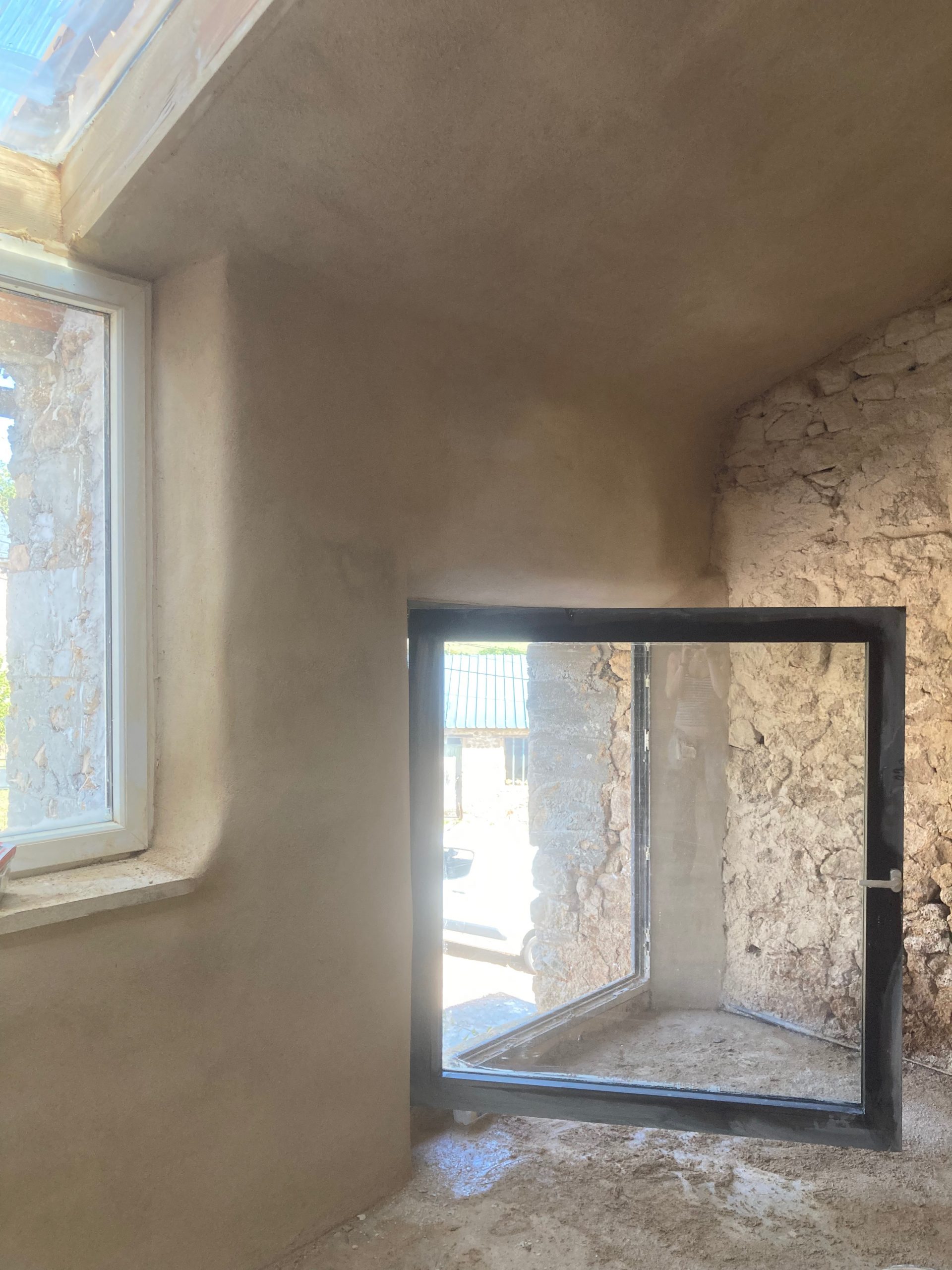 Embrasure de fenêtre enduite en argile, encadrement en pierre