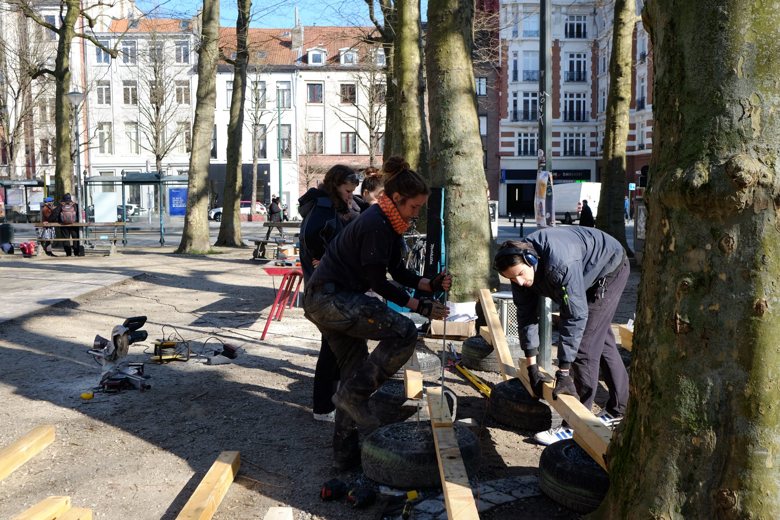 Participants assemblent le mobilier au pied des arbres du square