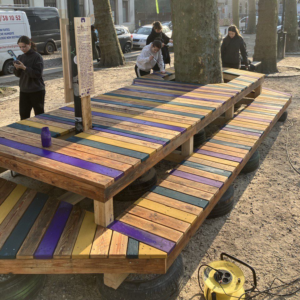 Les bancs aux lattes multicolores installés sur la place