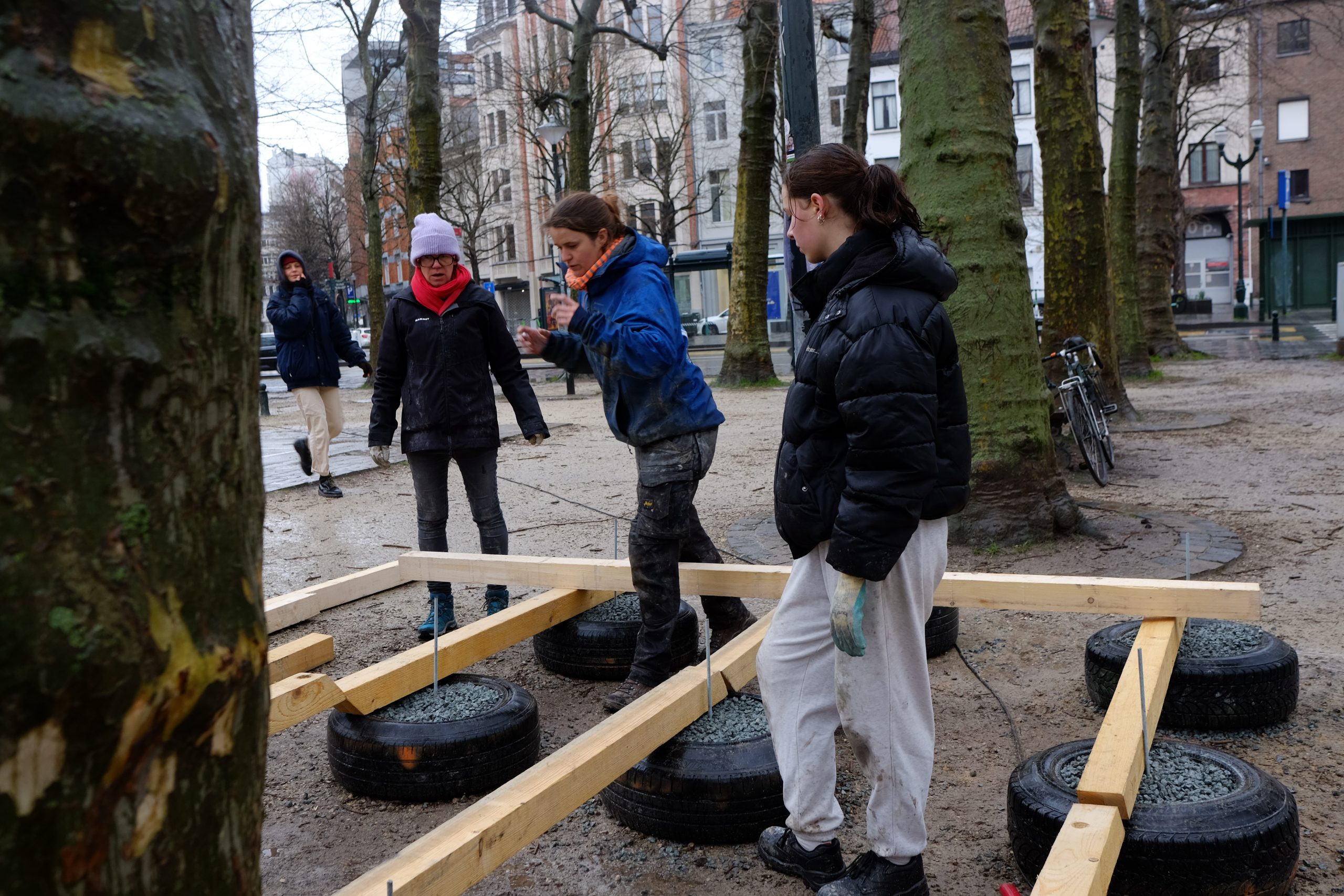 Participants autour d'une structure bois posée sur des pneus