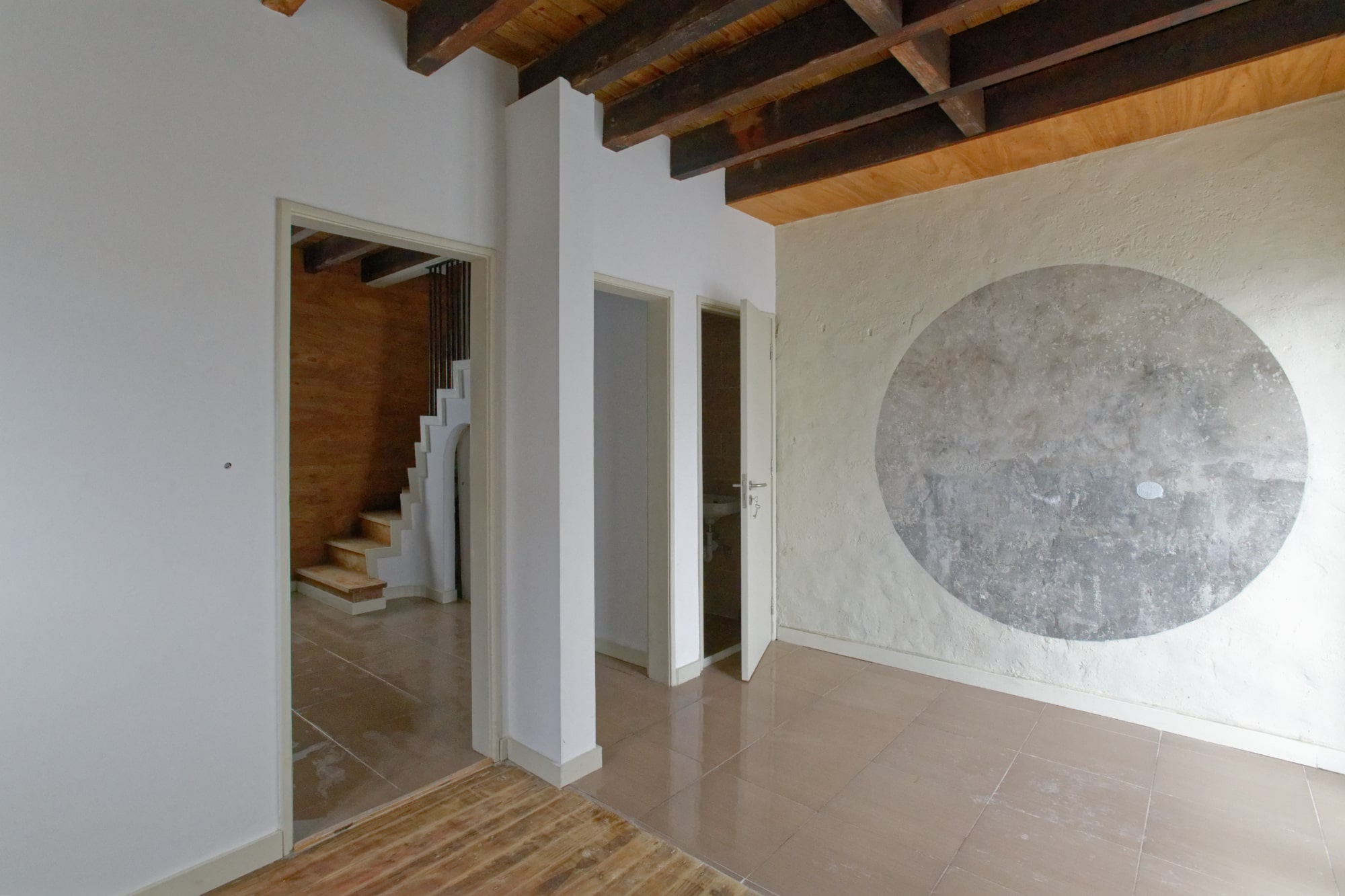 Couloir rénové avec escalier et médaillon décoratif au mur