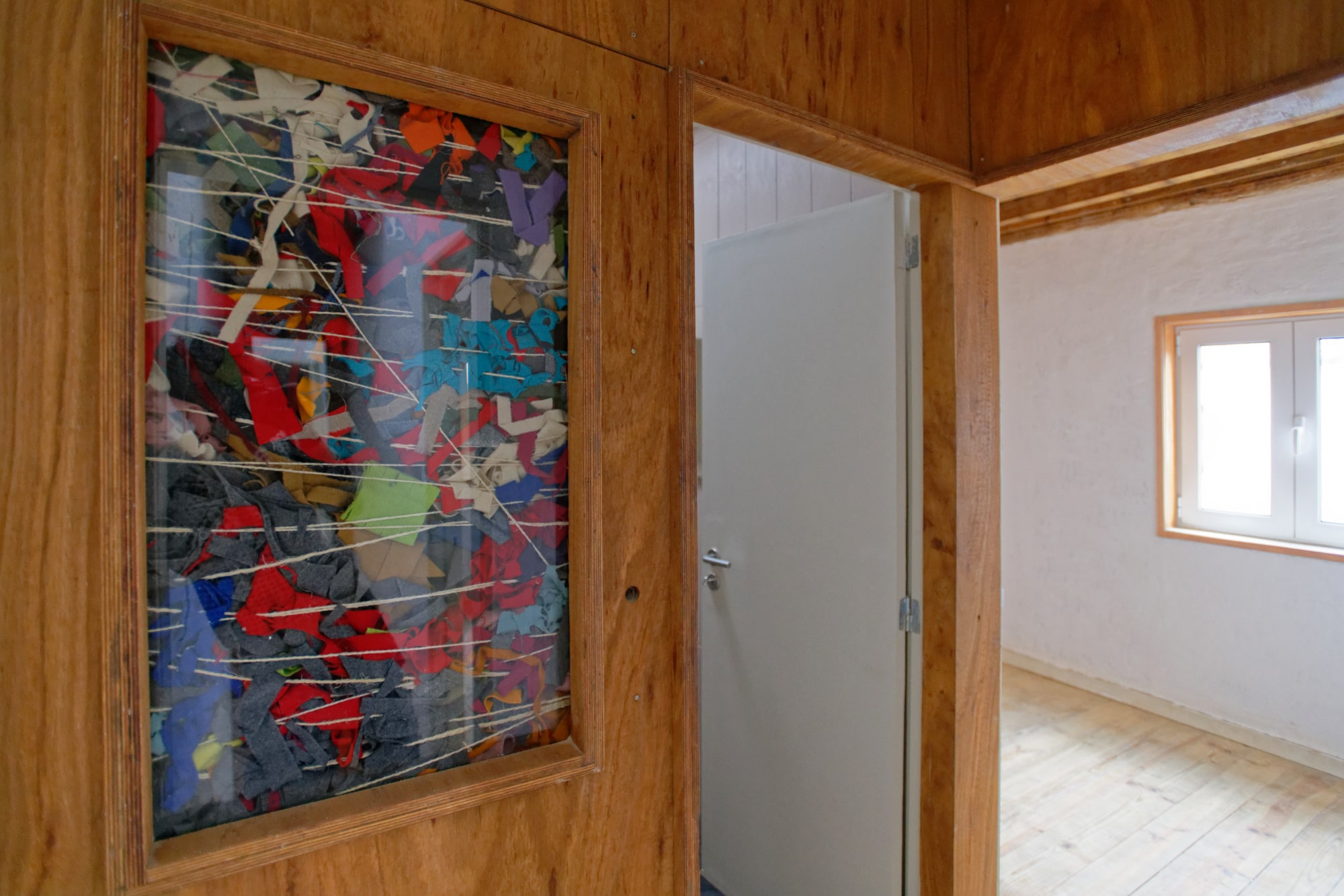 Panneau d'art coloré encadré sur un mur habillé de bois