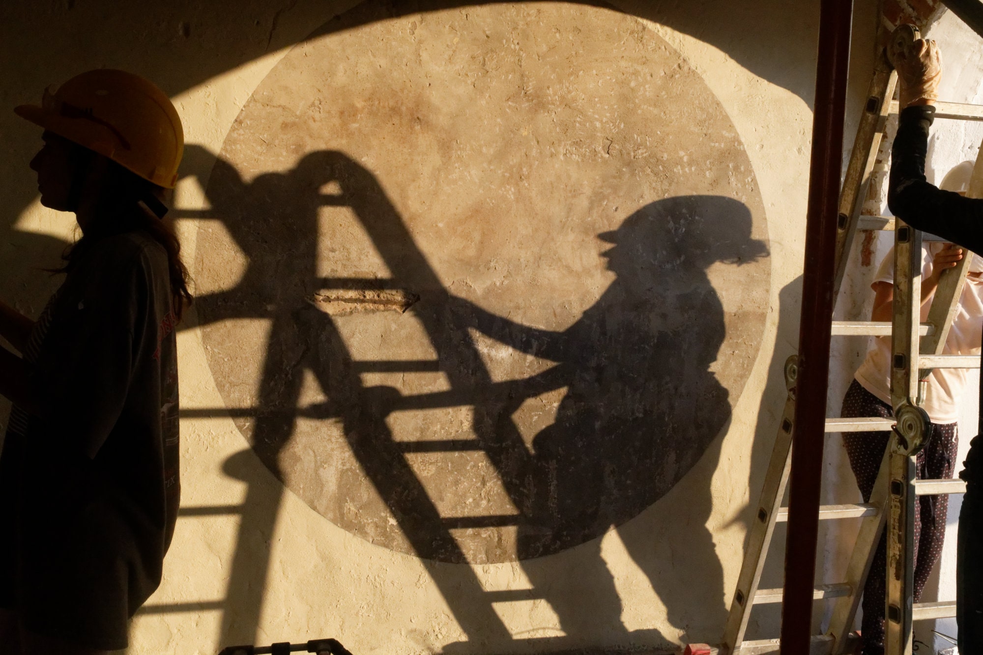 Ombres de participants projetées sur un grand cercle peint au mur