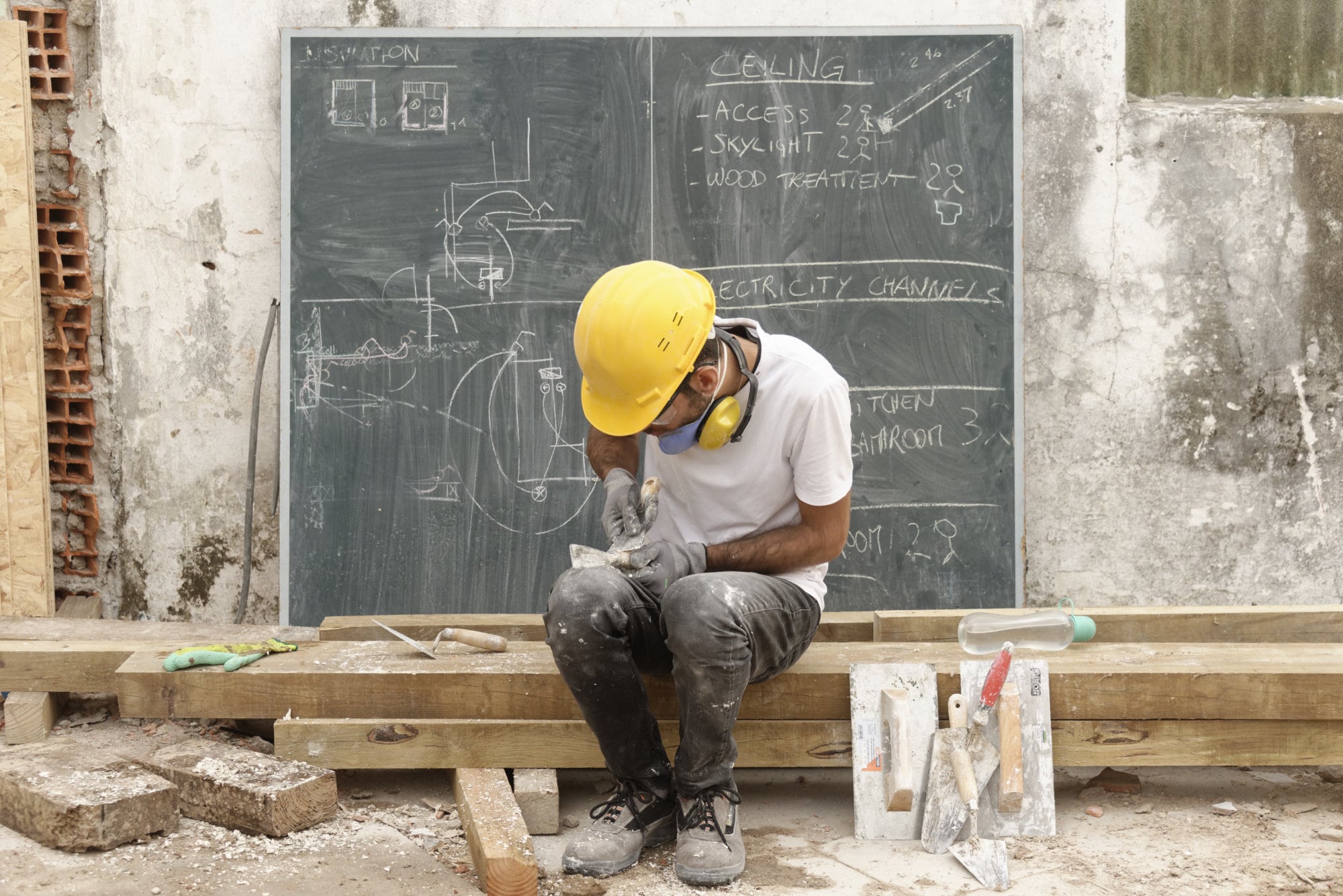 Un participant consulte un tableau noir de plans sur le chantier
