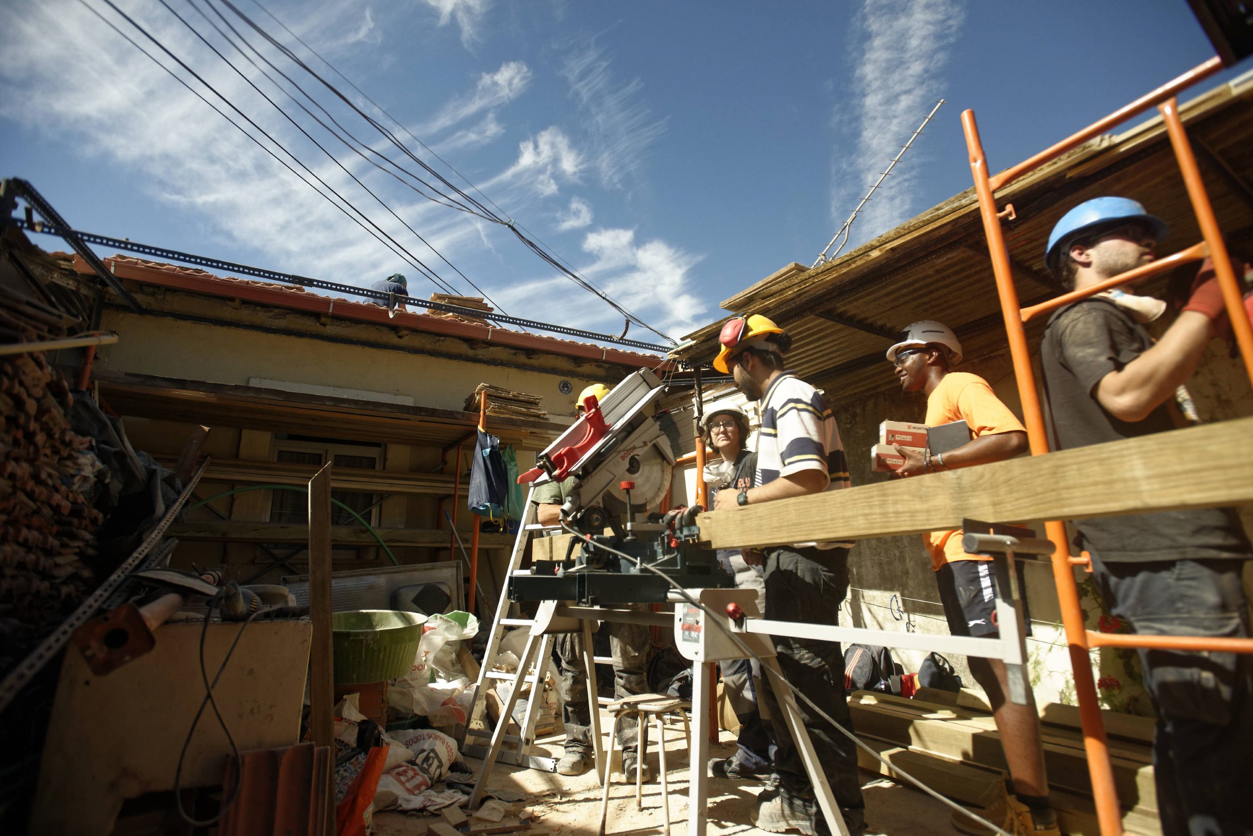 Participants travaillant sur un échafaudage extérieur, ciel bleu
