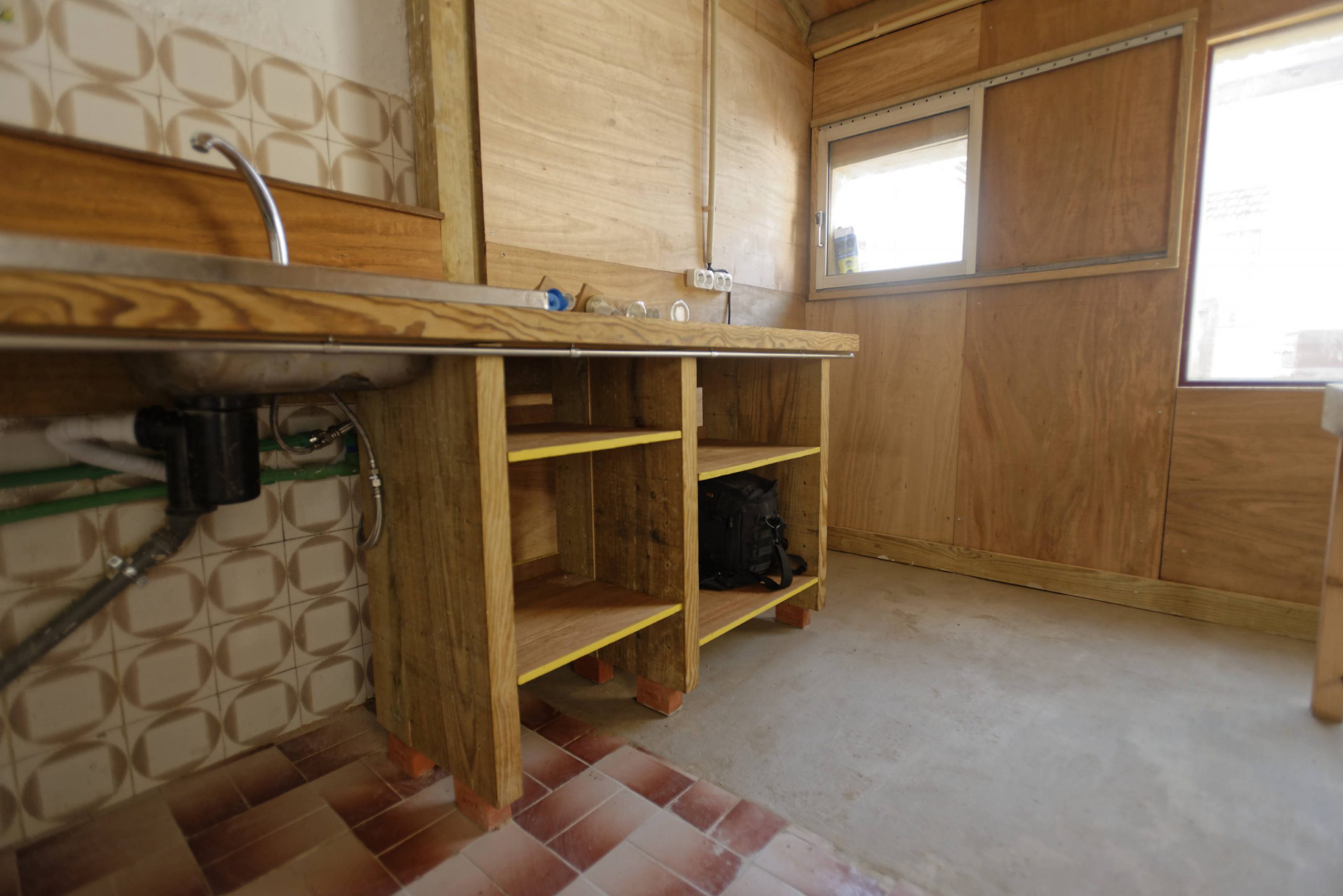 Cuisine sur mesure en bois avec plan de travail et sol carrelé