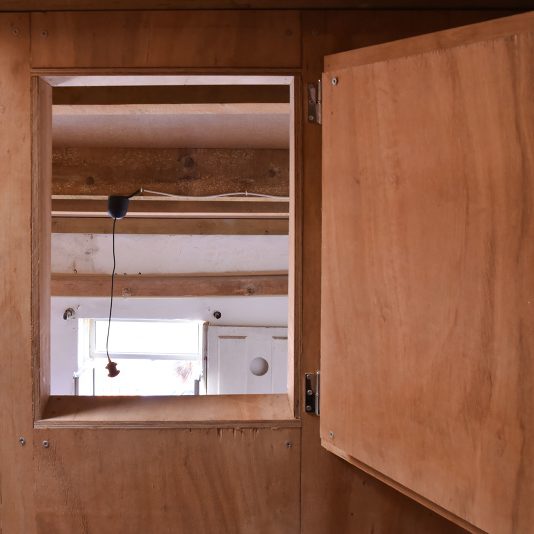 Meuble en bois avec trappe ouverte et ampoule, gros plan