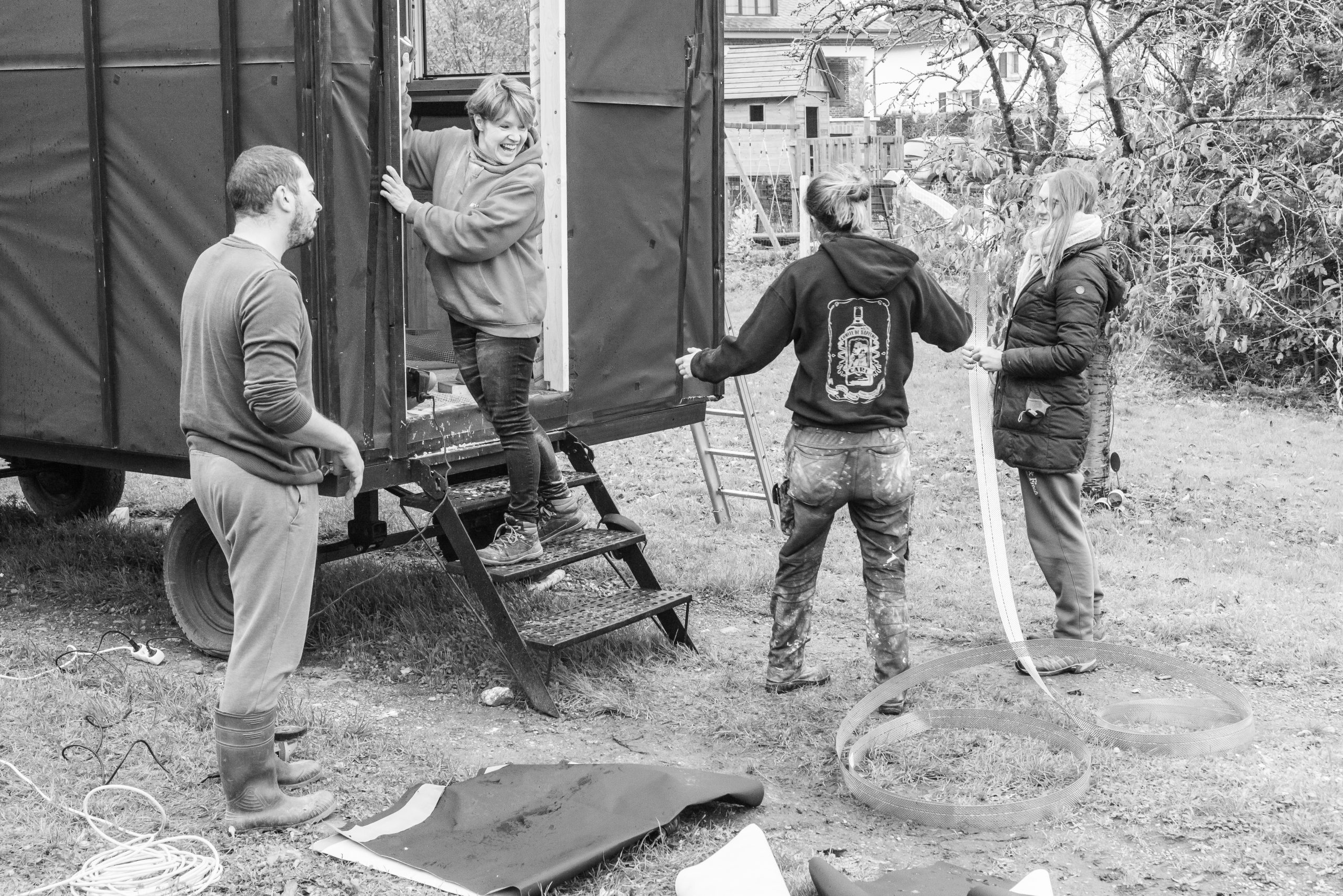 Participants manipulant les marches de la roulotte, image en noir et blanc