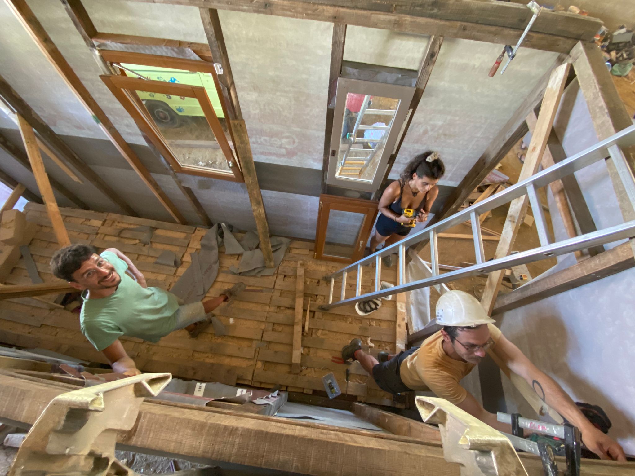 Pose de la charpente sous le hangar pendant un chantier participatif