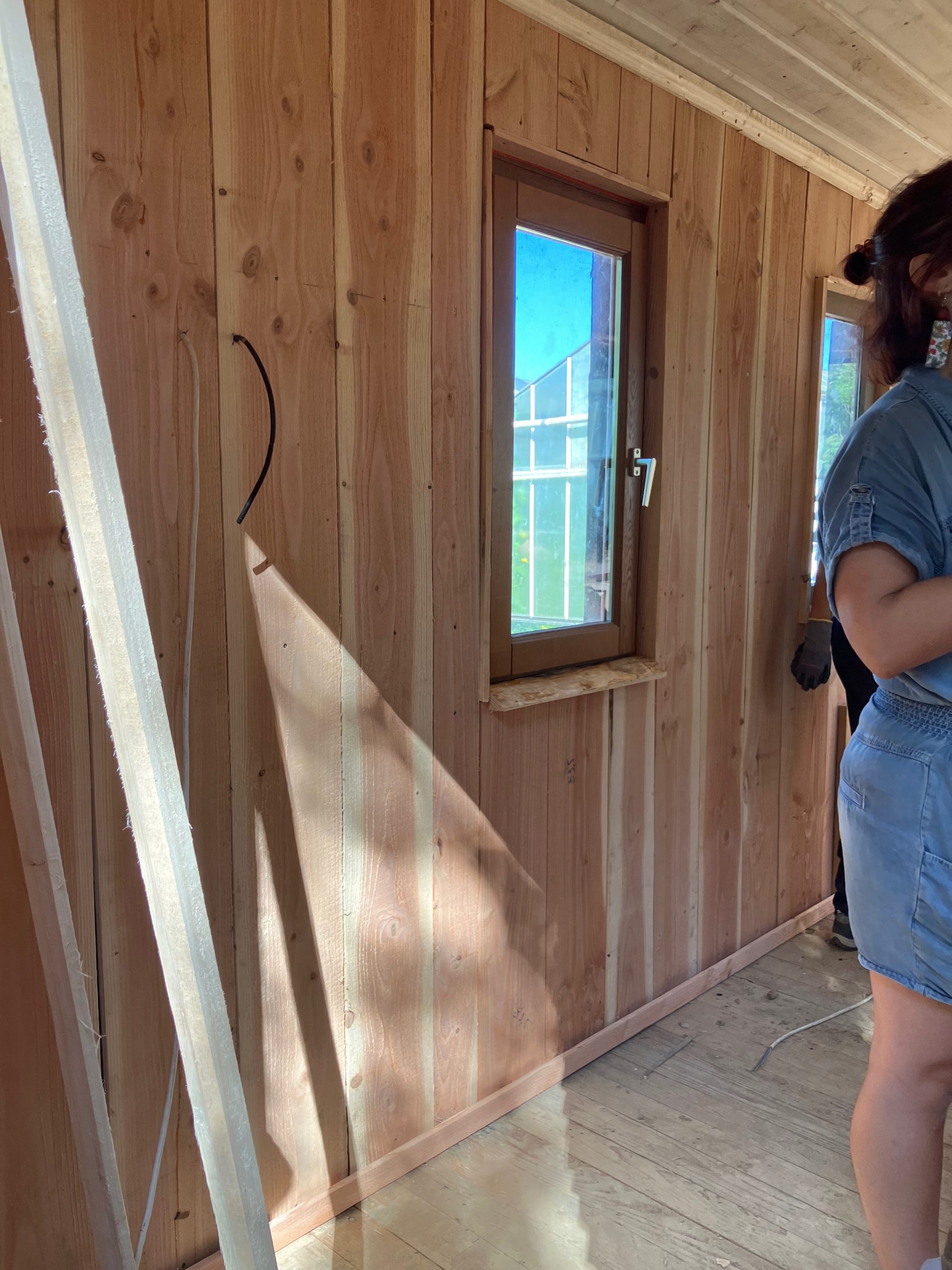 Détail intérieur : bardage en bois clair autour d’une fenêtre